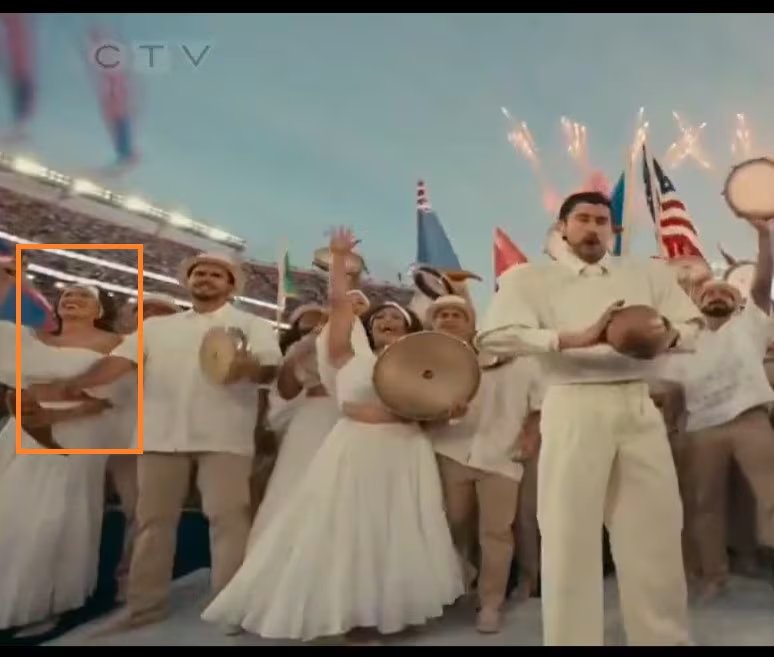 Lu Arróspide sonríe mientras baila entre un grupo de artistas vestidos de blanco, celebrando con música y fuegos artificiales en un vibrante escenario (ESPN)