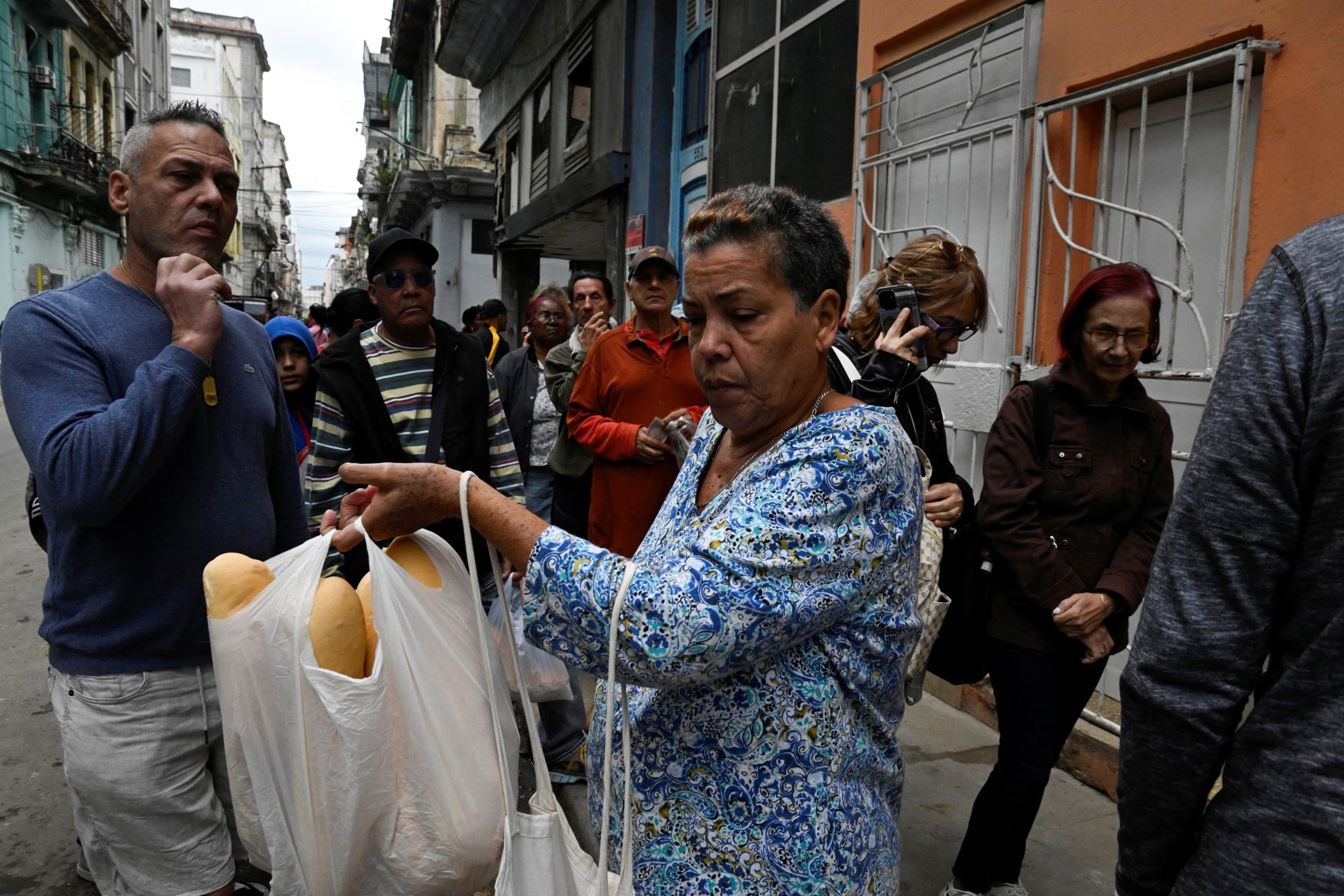 La gente hace fila para comprar pan en La Habana, mientras cubanos de todos los ámbitos de la vida se refugian en un modo de supervivencia, sorteando apagones aparentemente interminables y precios altísimos de alimentos, combustible y transporte (REUTERS/Norlys Perez)