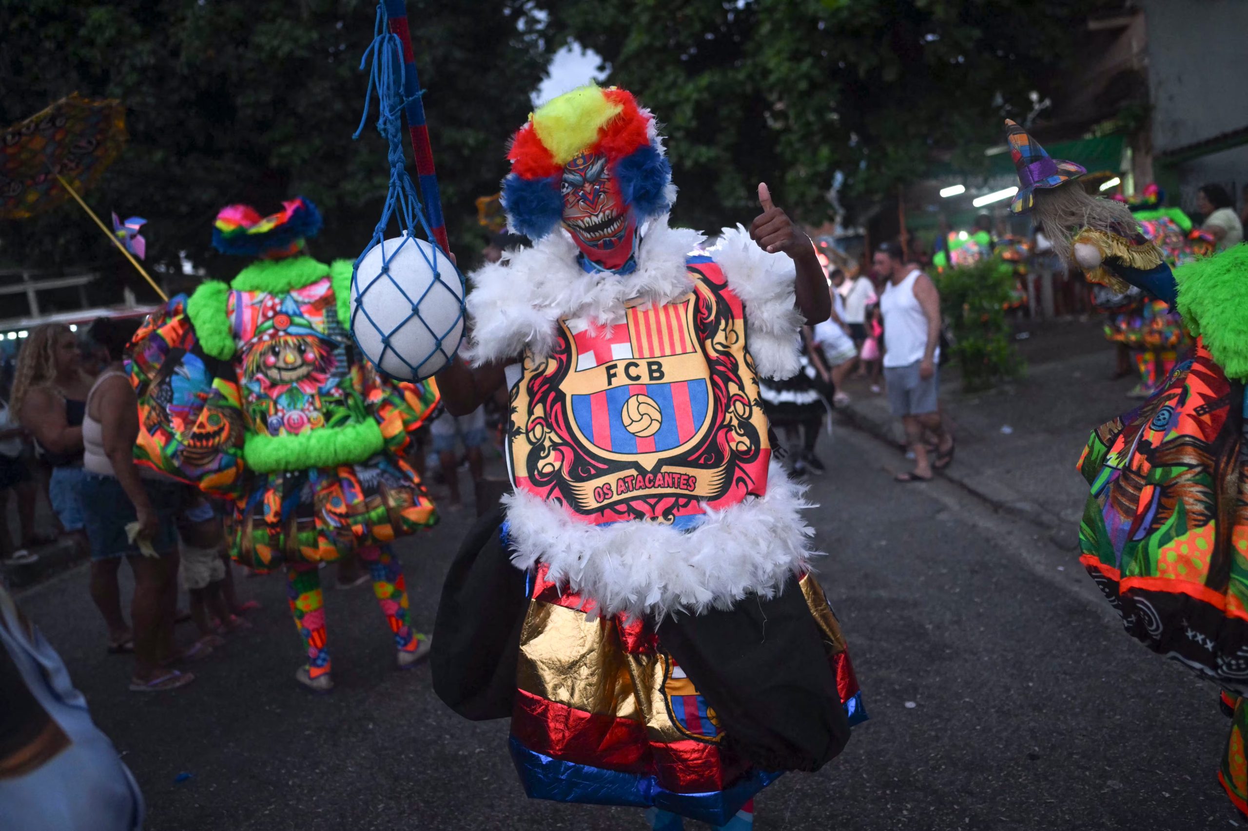 Un juerguista viste un traje del FC Barcelona durante el desfile del grupo de carnaval callejero Dito e Feito bate-bola en el barrio de Iraja, en los suburbios de Río de Janeiro, Brasil (Mauro PIMENTEL / AFP)