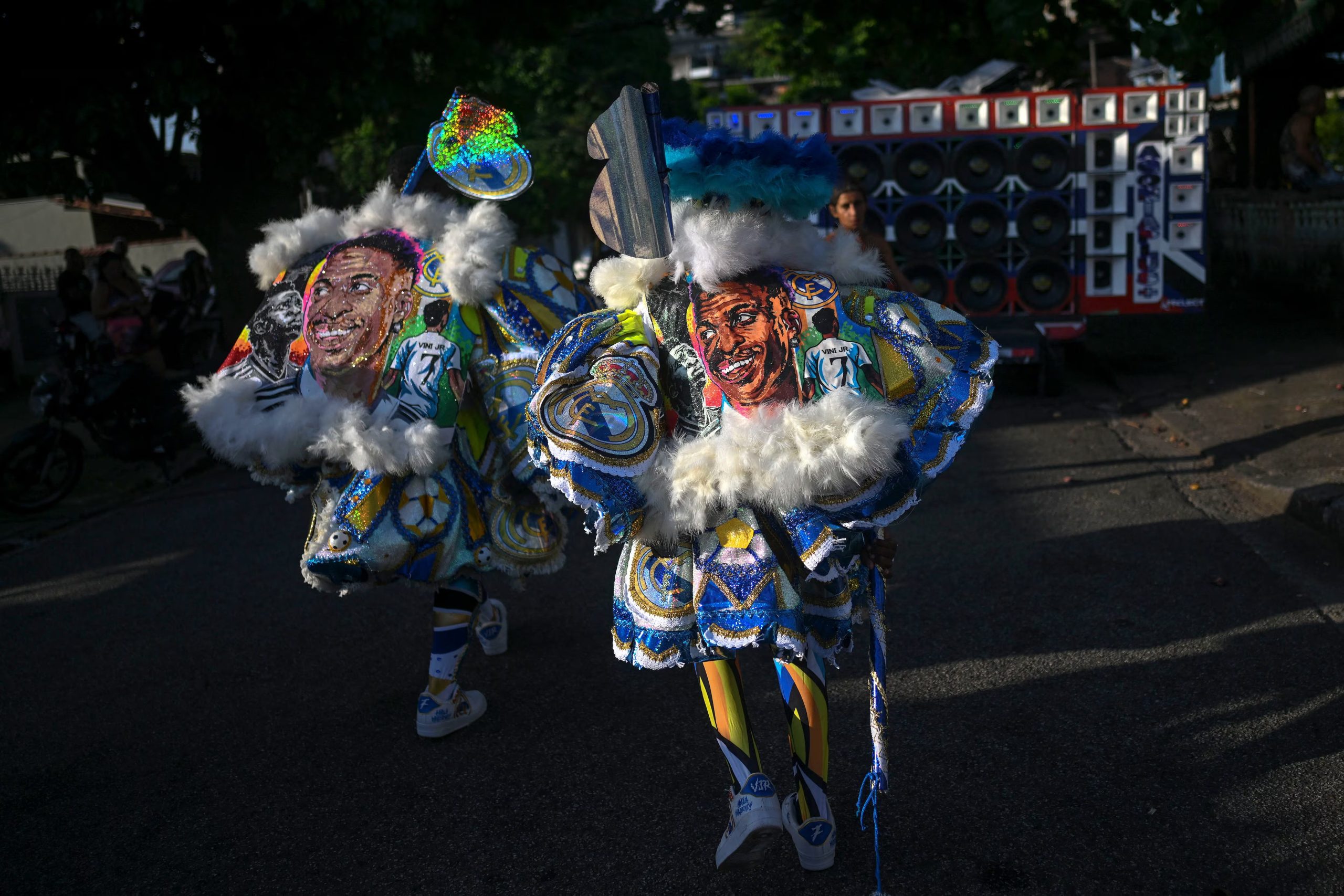 Un juerguista viste un disfraz que representa al delantero brasileño del Real Madrid Vinicius Junior durante el desfile del grupo de bate-bola Dito e Feito en el barrio de Iraja, en los suburbios de Río de Janeiro (Mauro PIMENTEL / AFP)