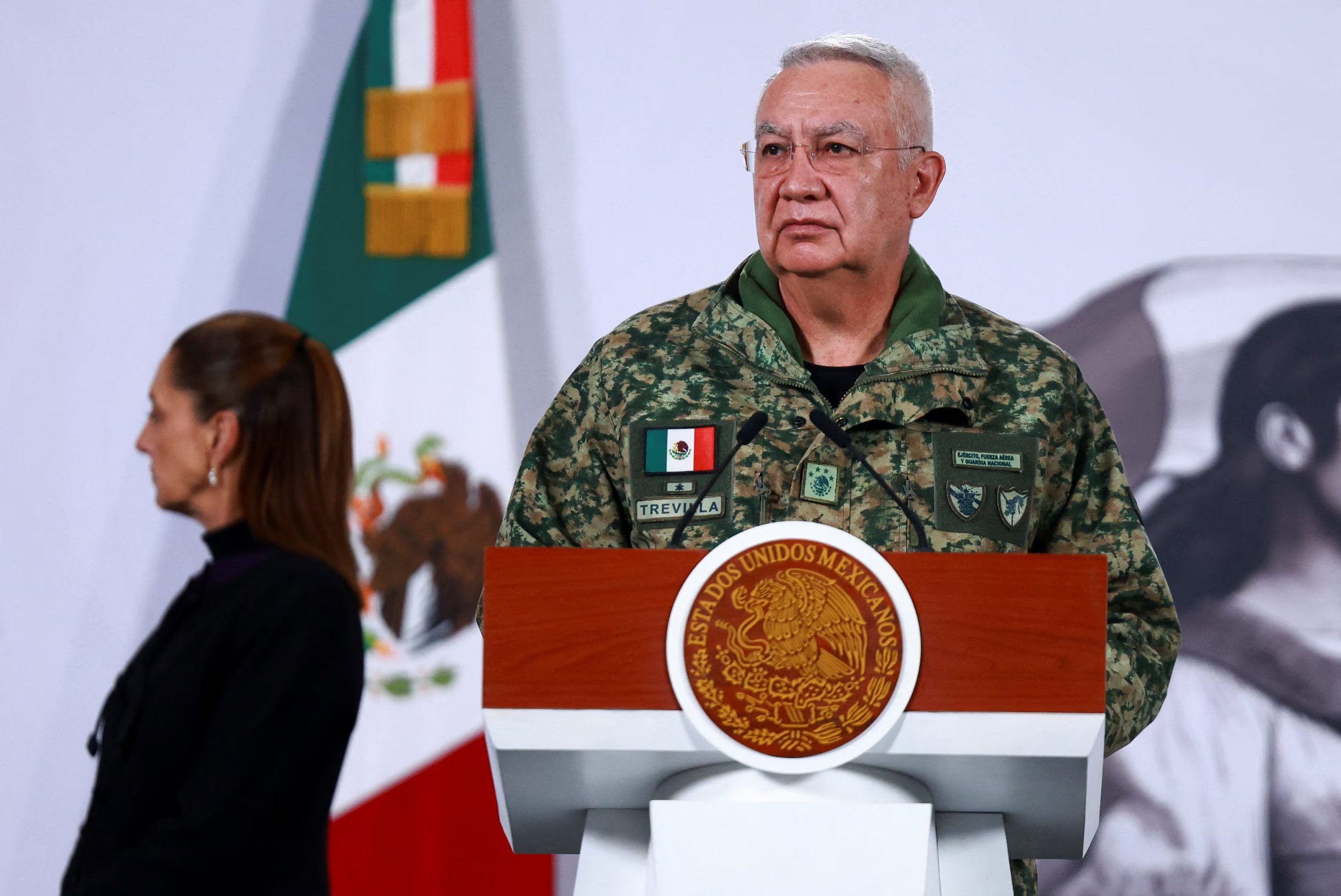 Mexico's Defense Minister Ricardo Trevilla Trejo and Mexico's President Claudia Sheinbaum attend a press conference about the wave of violence in Mexico, following the killing of Mexican drug lord Nemesio Oseguera, known as 'El Mencho', in a military operation on Sunday, at Palacio Nacional, in Mexico City, Mexico, February 23, 2026. REUTERS/Raquel Cunha
