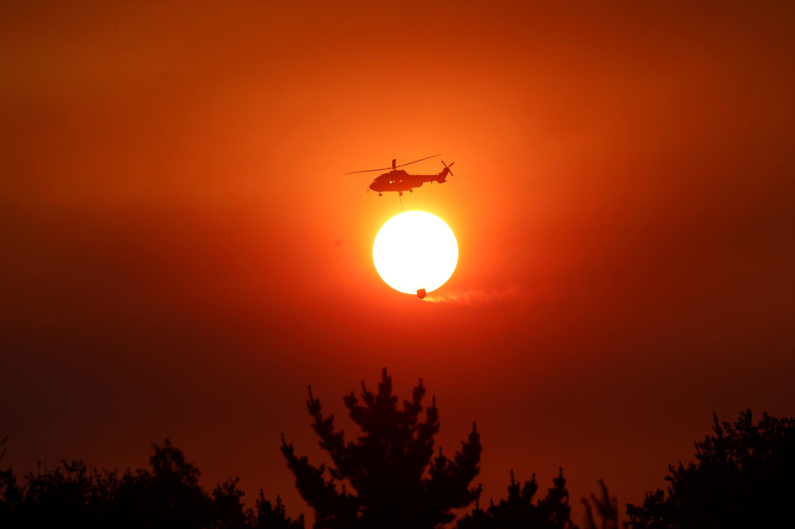 Un helicóptero combate un incendio forestal en la región del Biobío, donde múltiples incendios forestales han provocado evacuaciones de emergencia, en Florida, Chile, (REUTERS/Adriano Machado)