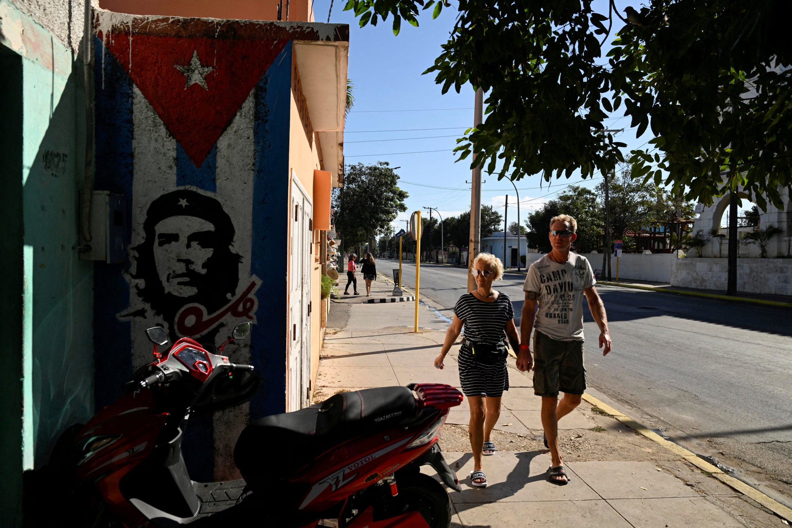 Turistas caminan junto a un mural del fallecido héroe revolucionario Che Guevara mientras Estados Unidos bloquea los envíos de petróleo que llegan a la nación insular, Varadero, Cuba, el 14 de febrero de 2026. REUTERS/Norlys Perez/Foto de archivo