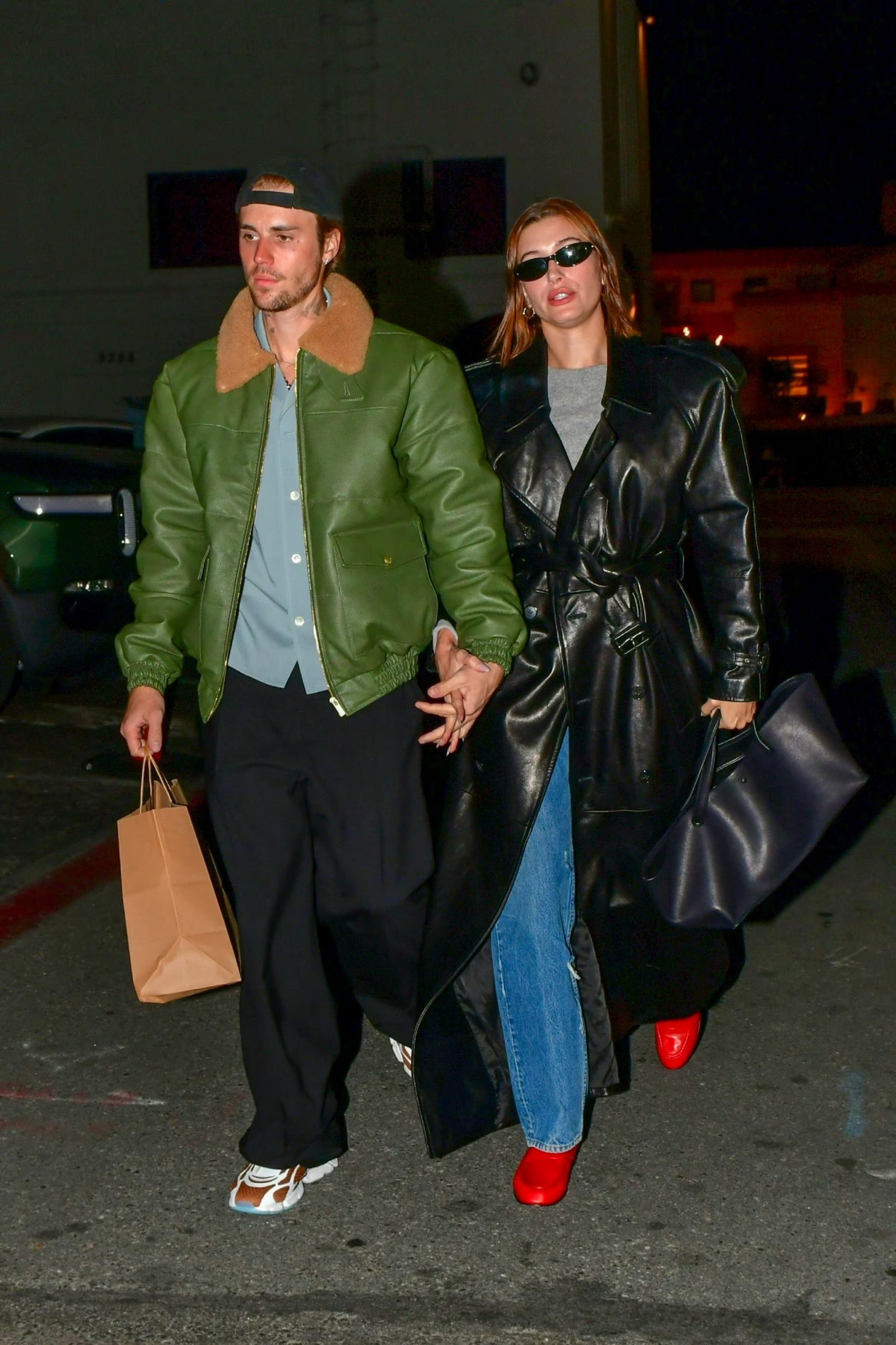 El abrigo largo de cuero y los zapatos rojos destacan la capacidad de Hailey Bieber para romper la monocromía con detalles vibrantes (The Grosby Group)