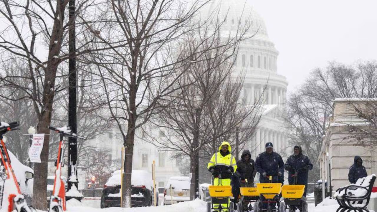 Equipos de mantenimiento limpian la nieve frente al Capitolio de EE. UU. en Washington D.C. durante una tormenta invernal que afectó la región.