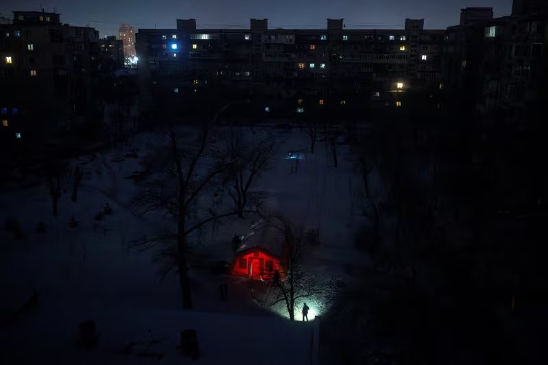 Una persona se ilumina con una linterna en una zona residencial que se quedó sin calefacción en Kiev, Ucrania. 17 enero 2026. REUTERS/Thomas Peter