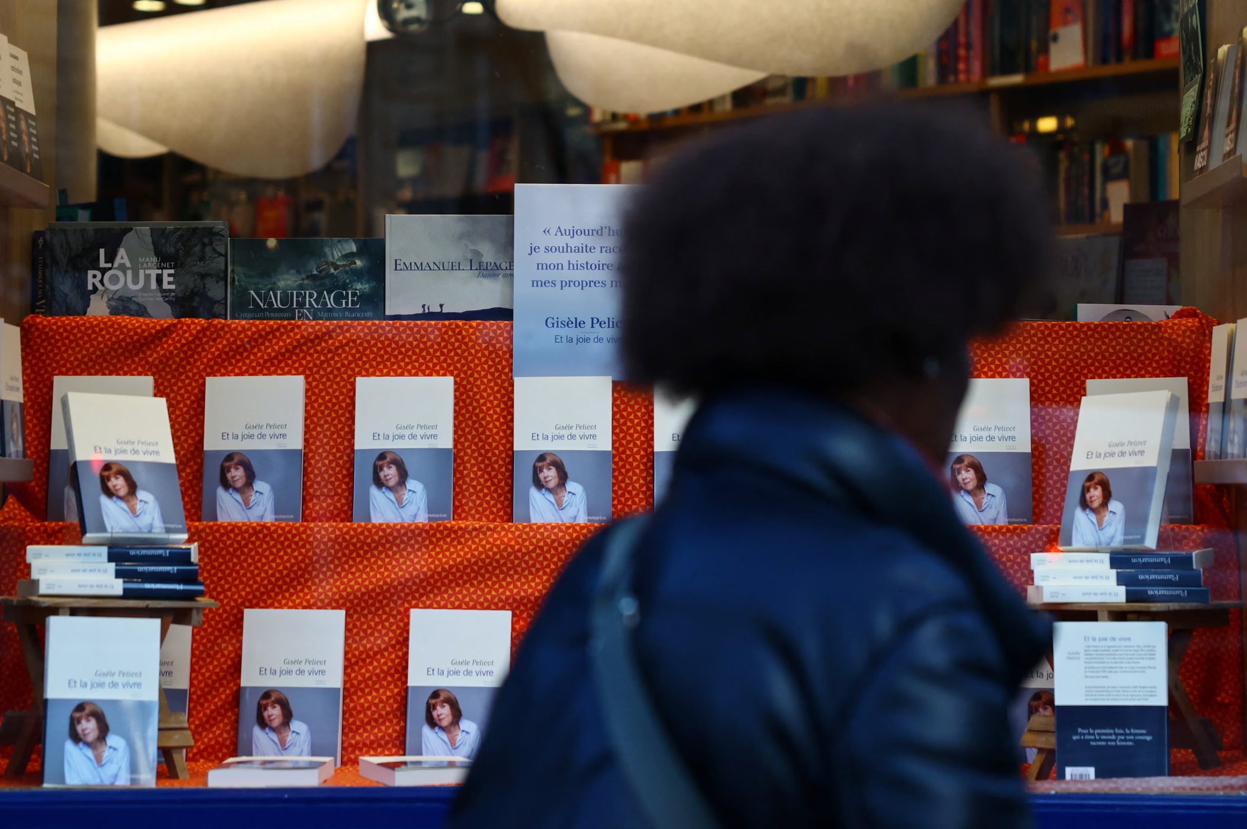 Una mujer mira un escaparate en el que se expone el libro de Gisèle Pelicot. (Sarah Meyssonnier/Reuters)