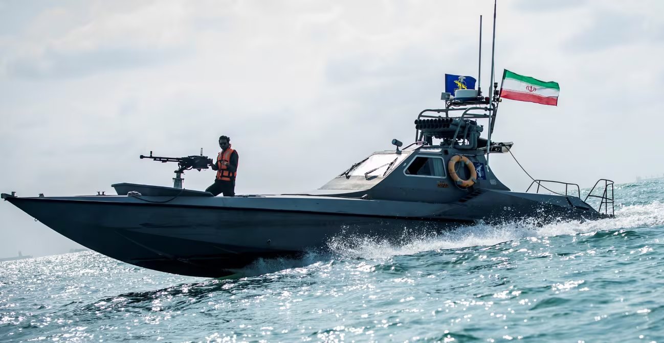 Una patrullera de la Armada iraní, con un tripulante armado en la proa, navega a gran velocidad bajo un cielo nublado, mostrando la bandera nacional (Imagen Ilustrativa Infobae)
