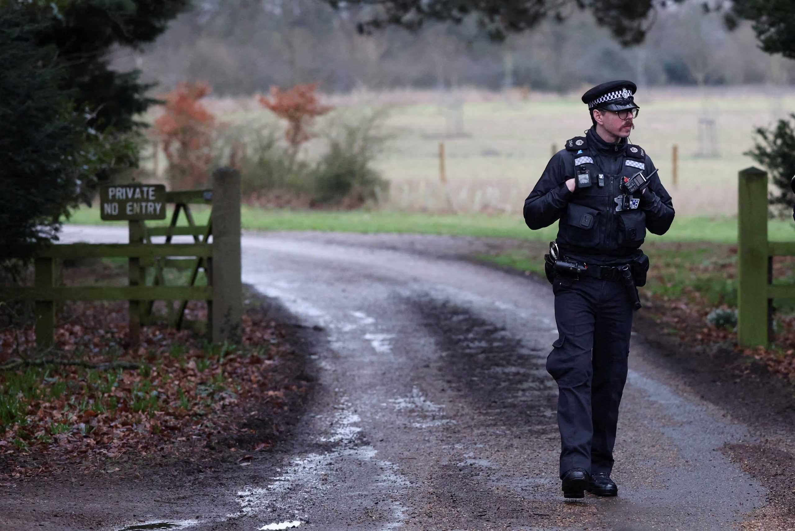 Un oficial de policía en la entrada de la granja de madera en la finca de Sandringham, que se informó que está sirviendo como alojamiento provisional para Andrew Mountbatten Windsor, hermano menor del rey Carlos III de Gran Bretaña, que fue detenido esta mañana bajo sospecha de mala conducta en un cargo público, el 19 de febrero de 2026 (REUTERS/Chris Radburn)