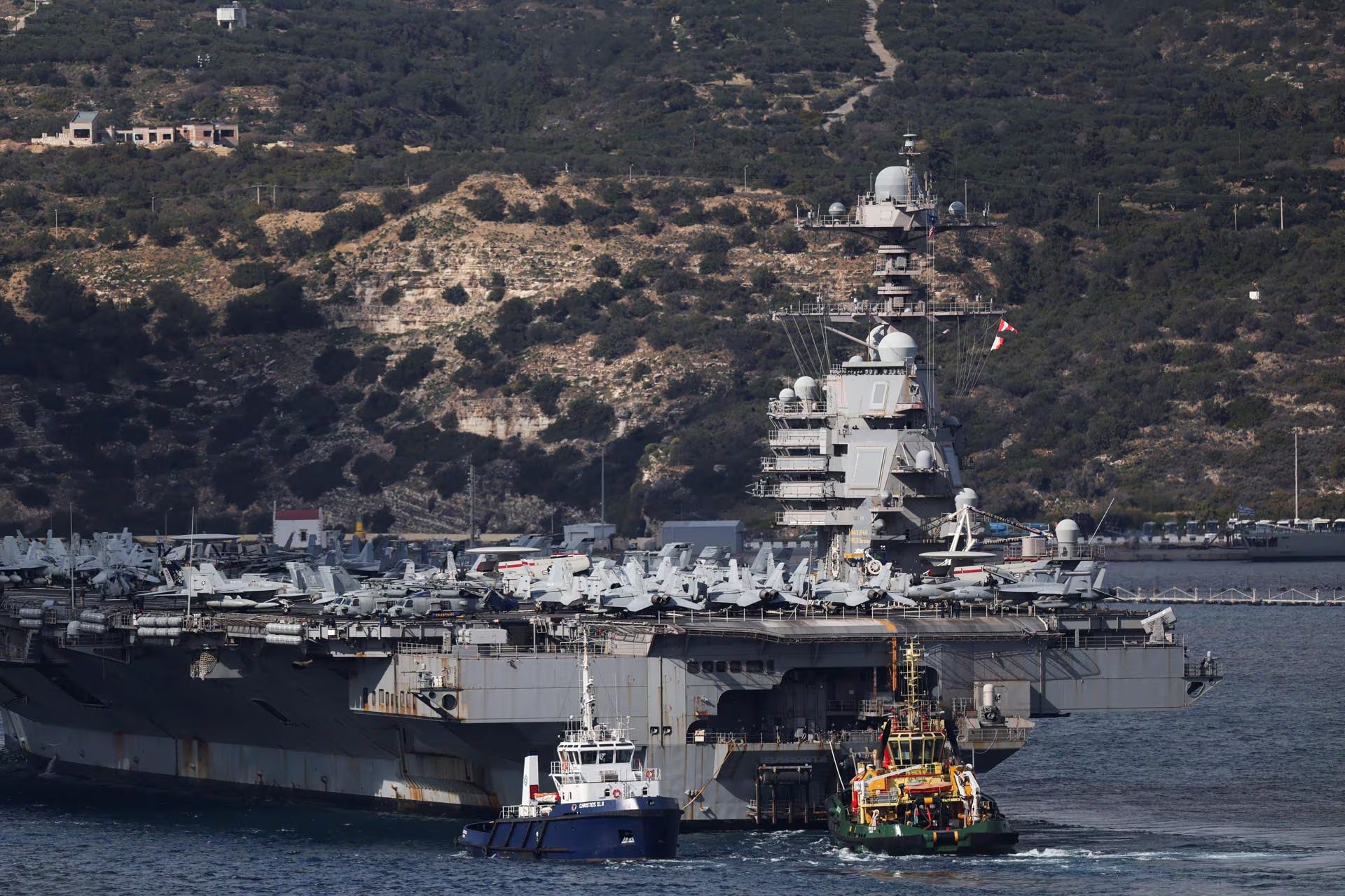 El portaaviones de la Armada de EE.UU. USS Gerald R. Ford llega a la Bahía de Souda en la isla de Creta, asistido por remolcadores. (Reuters)