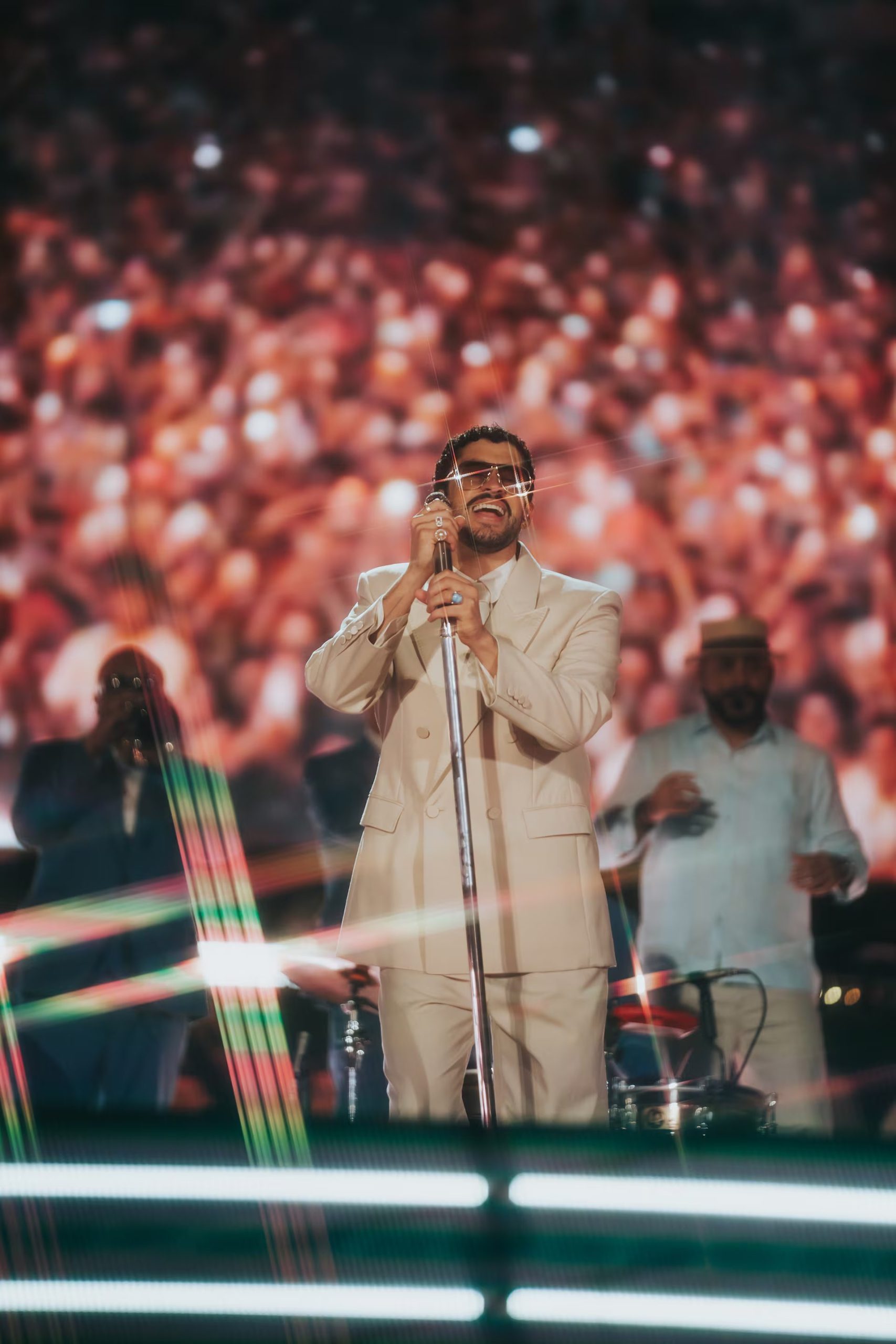 Traje sastre marfil, camisa clara y corbata al tono: Bad Bunny abre el show con una apuesta elegante y sofisticada, marcando el inicio de una noche de contrastes estilísticos