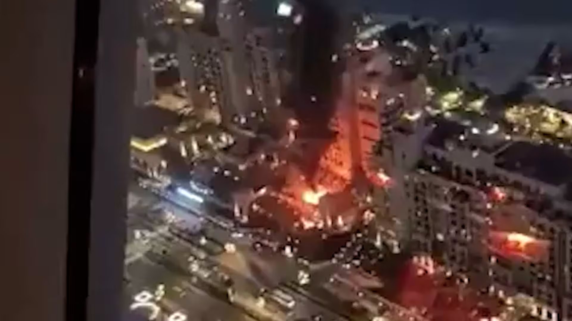 Un hotel de lujo en Dubái es visto envuelto en llamas durante un ataque atribuido a Irán, con el resplandor del fuego iluminando la noche urbana.