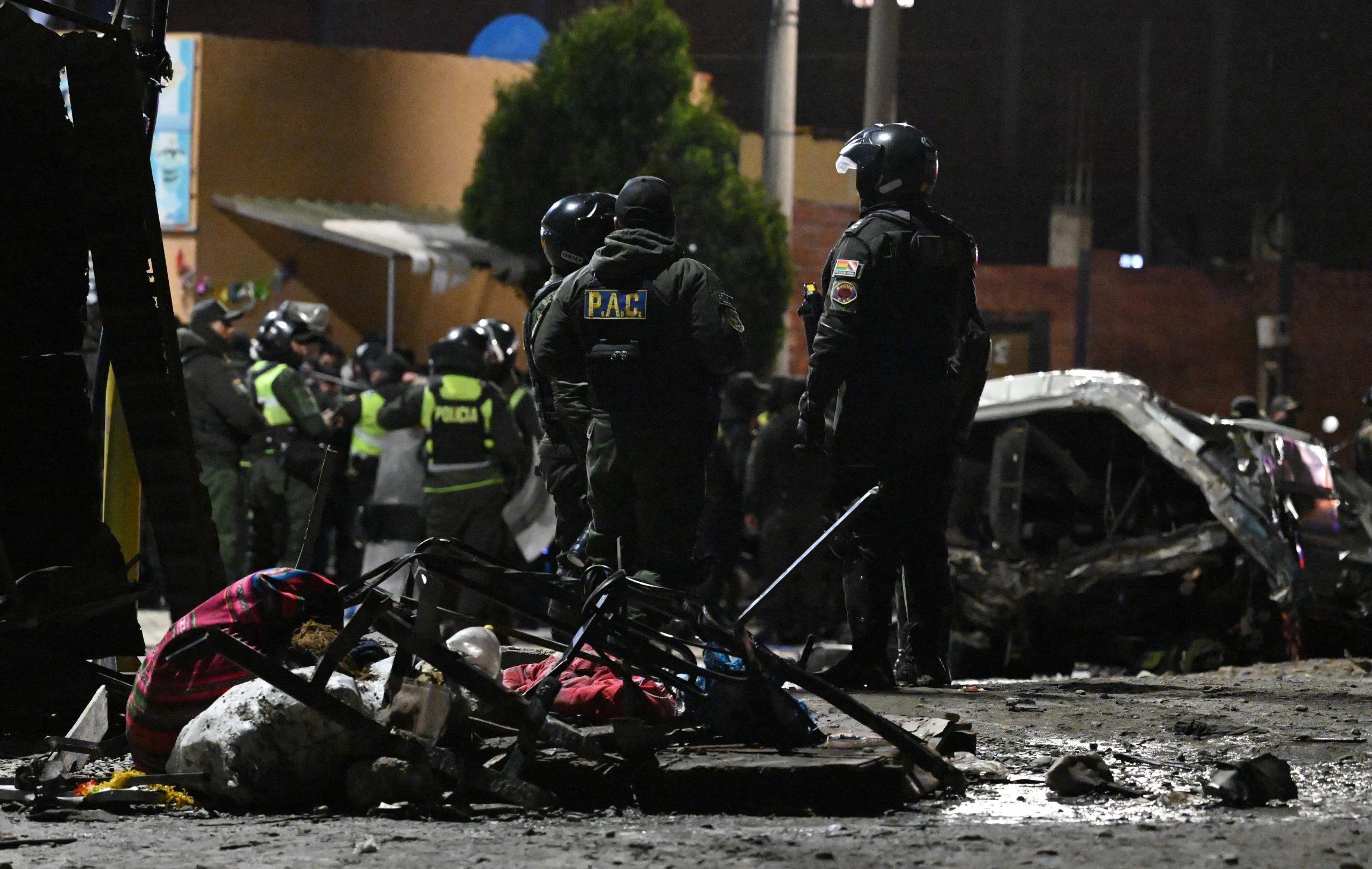 Personal de emergencia se reúne en el lugar donde un avión Hércules de la Fuerza Aérea Boliviana se estrelló el viernes por la noche en una concurrida avenida en medio de un clima inclemente en la ciudad de El Alto, Bolivia, el 27 de febrero de 2026 (REUTERS/Claudia Morales)