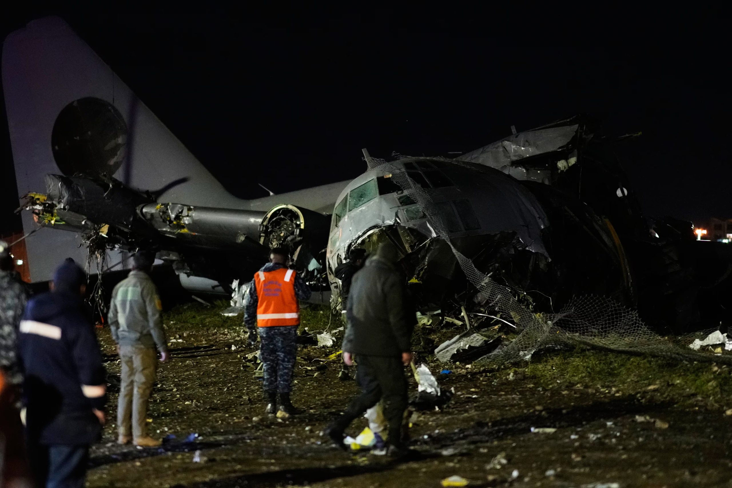 La gente camina en el lugar donde un avión se estrelló en una carretera en El Alto (AP/Juan Karita)