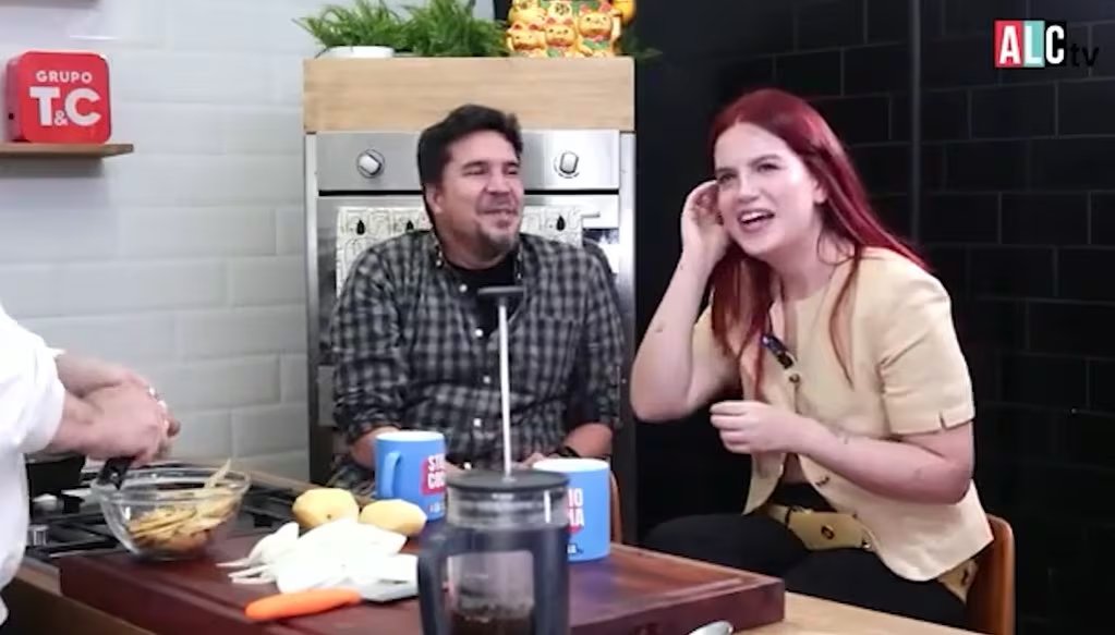 Nicole Zignago, con su característica sonrisa, revela durante una aparición televisiva que mantiene una relación con un artista internacional, mientras comparte en un ambiente de cocina. (YouTube - Ala Cocina TV)