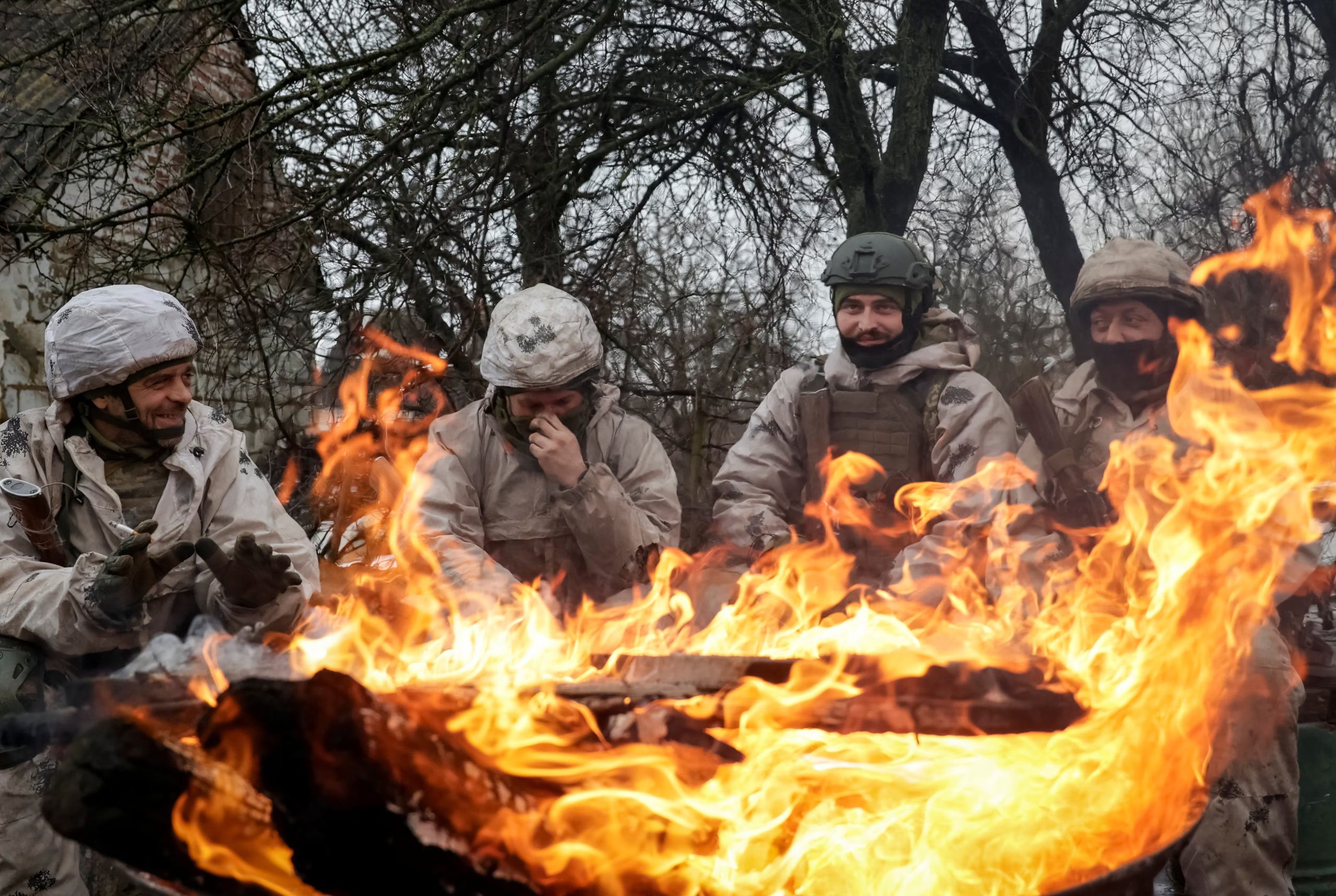Los reclutas de la 28ª Brigada Mecanizada Independiente de las Fuerzas Armadas de Ucrania se calientan junto al fuego durante un ejercicio militar antes de las misiones de combate en la región de Kharkiv (REUTERS/Sofiia Gatilova)