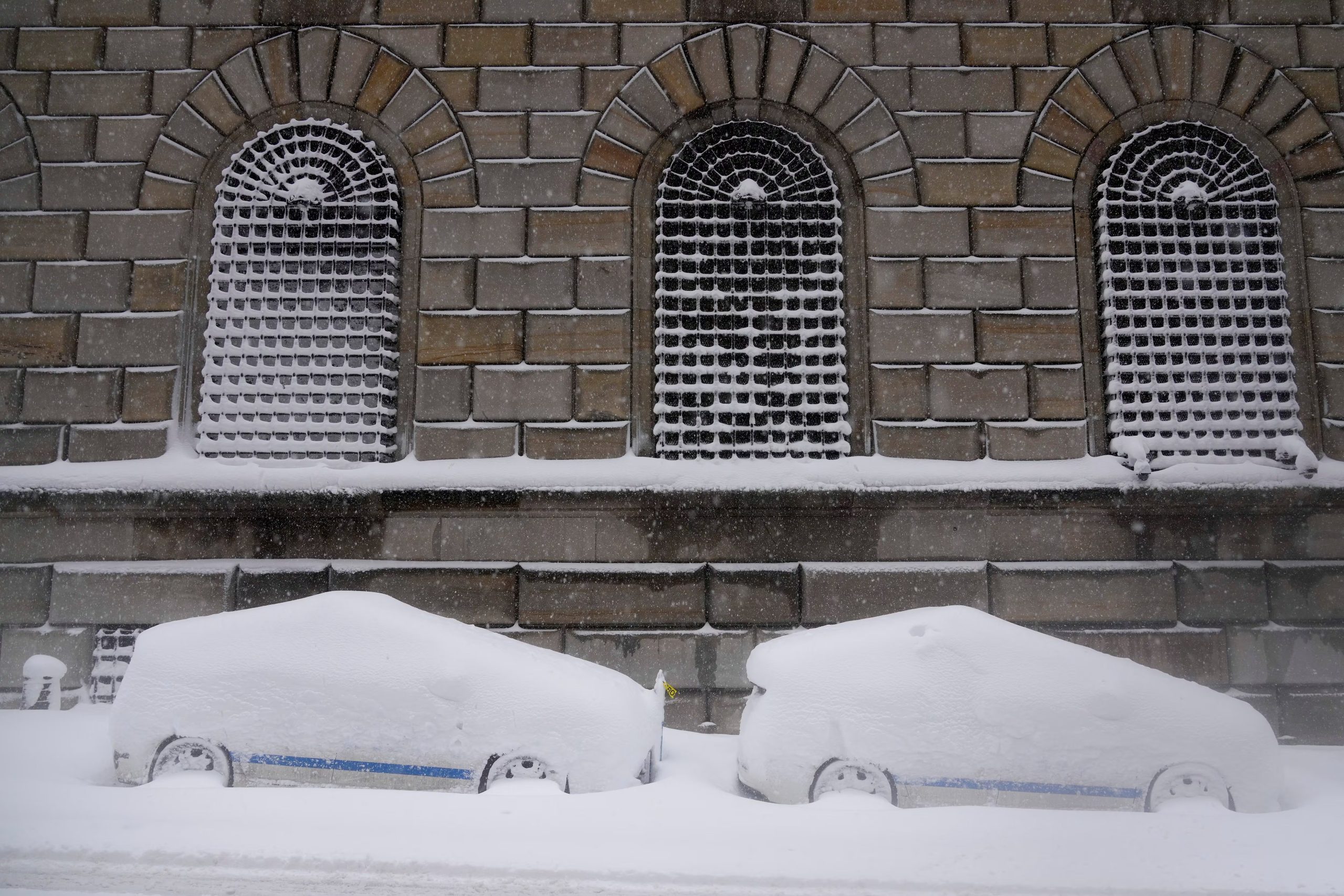 Vehículos urbanos estacionados cubiertos de nieve en el bajo Manhattan durante la tormenta de nieve que afecta al este de Estados Unidos (AP/Seth Wenig)