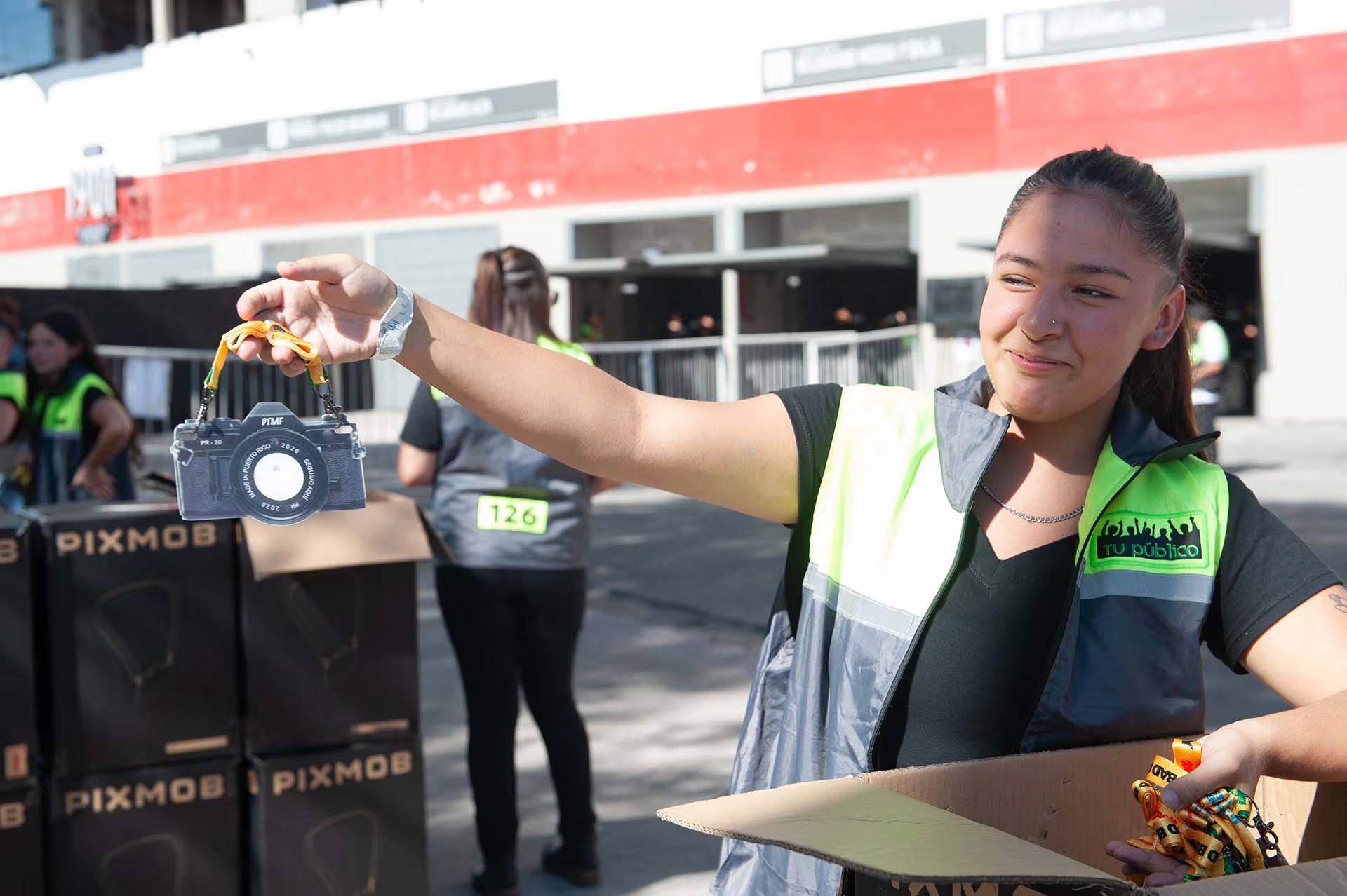 El staff distribuye colgantes identificatorios a la entrada del recital de Bad Bunny (Jaime Olivos)