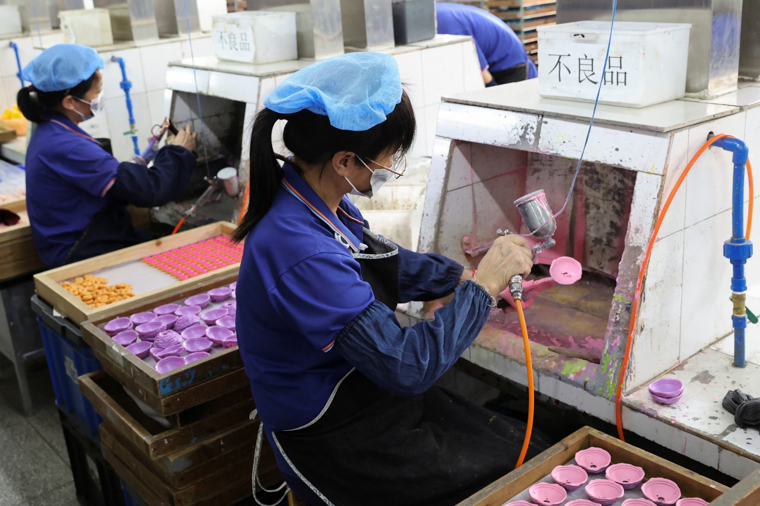 Empleados de Shaoguan Guanghua Plastic & Hardware Products Co., Ltd. pintan con aerosol piezas de juguetes en la fábrica de Shaoguan, provincia de Guangdong, China, el 9 de mayo de 2025. REUTERS/Go Nakamura