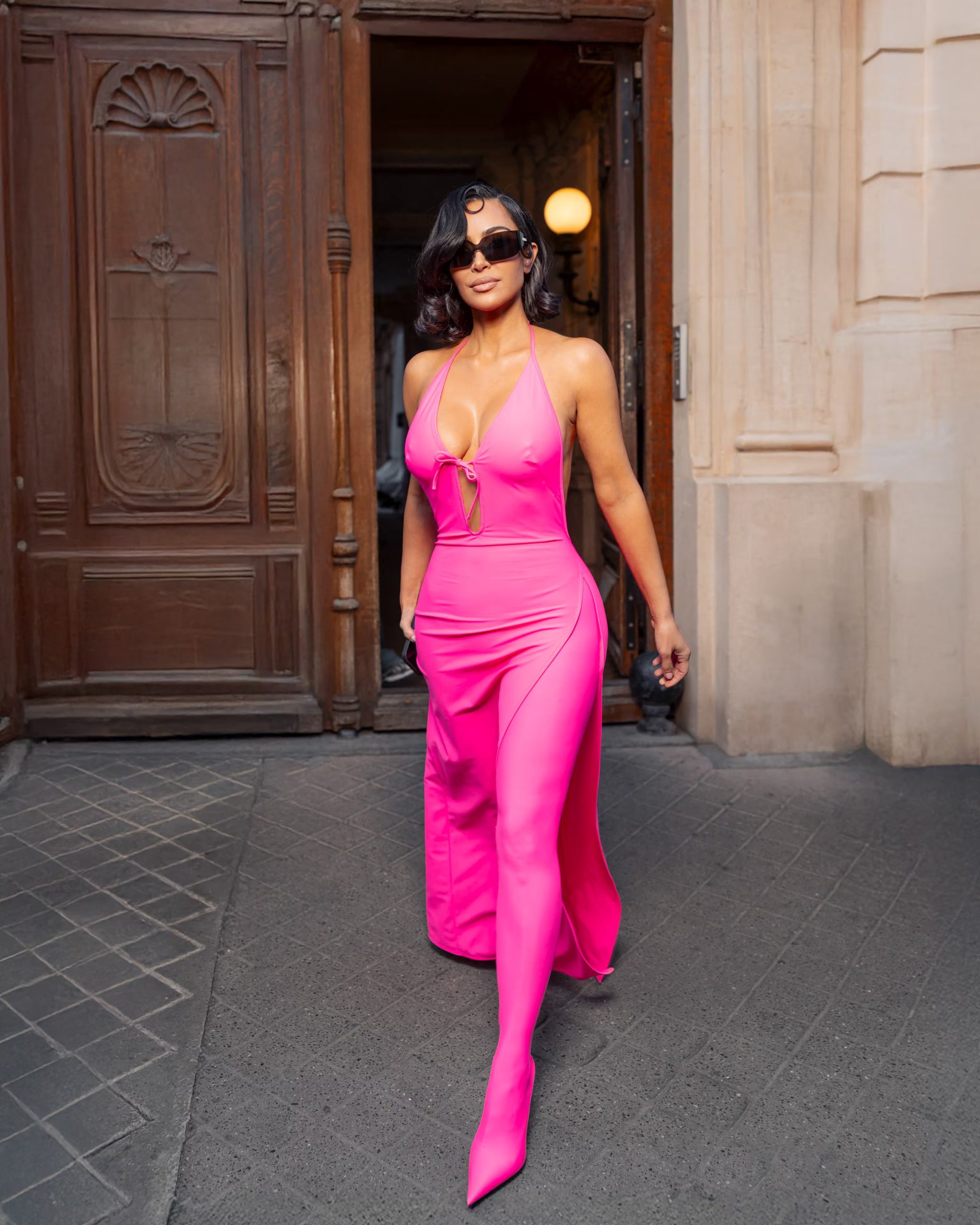 El vestido rosa neón con botas a juego demuestra la capacidad de Kim Kardashian para imponer colores vibrantes y tendencias inesperadas en el mundo de la moda (The Grosby Group)