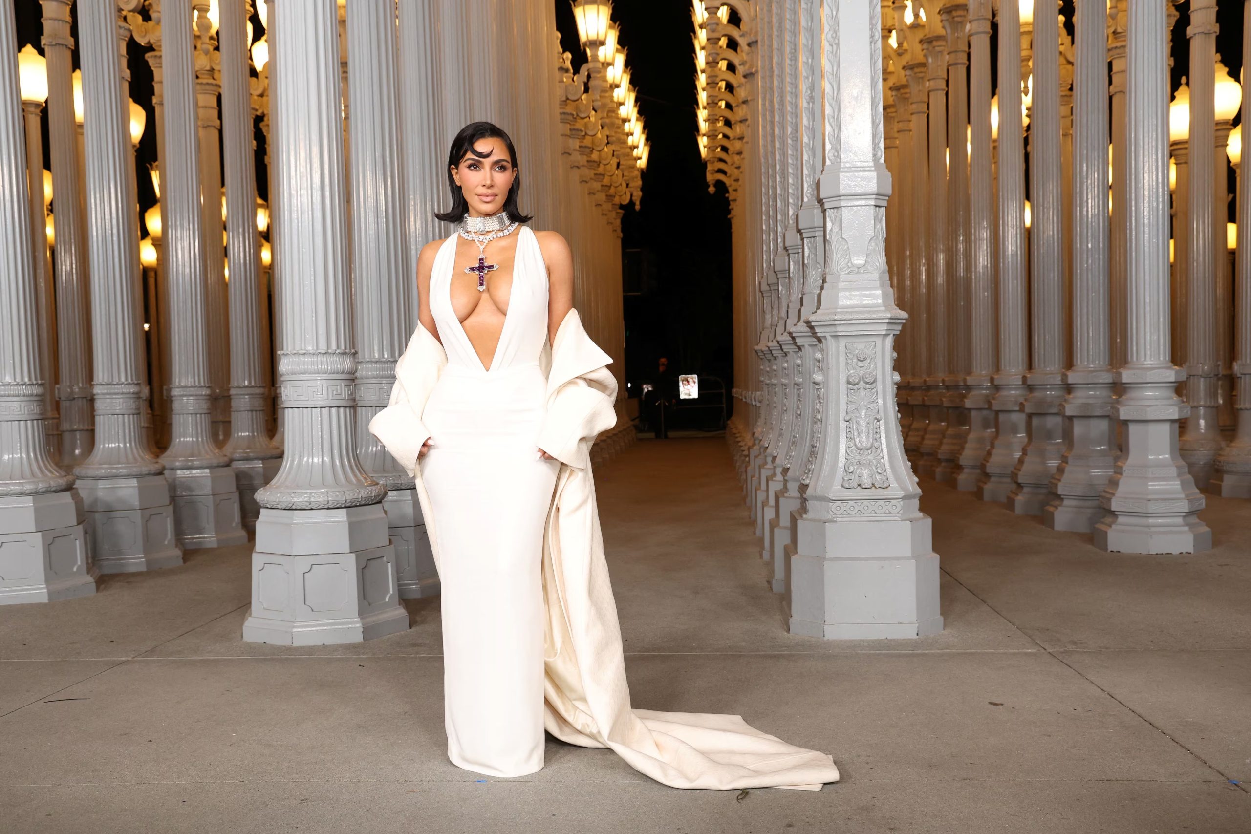 El vestido marfil con cola y abrigo a juego destaca la preferencia de Kim Kardashian por las siluetas clásicas renovadas con detalles brillantes y accesorios impactantes (REUTERS/Mario Anzuoni)