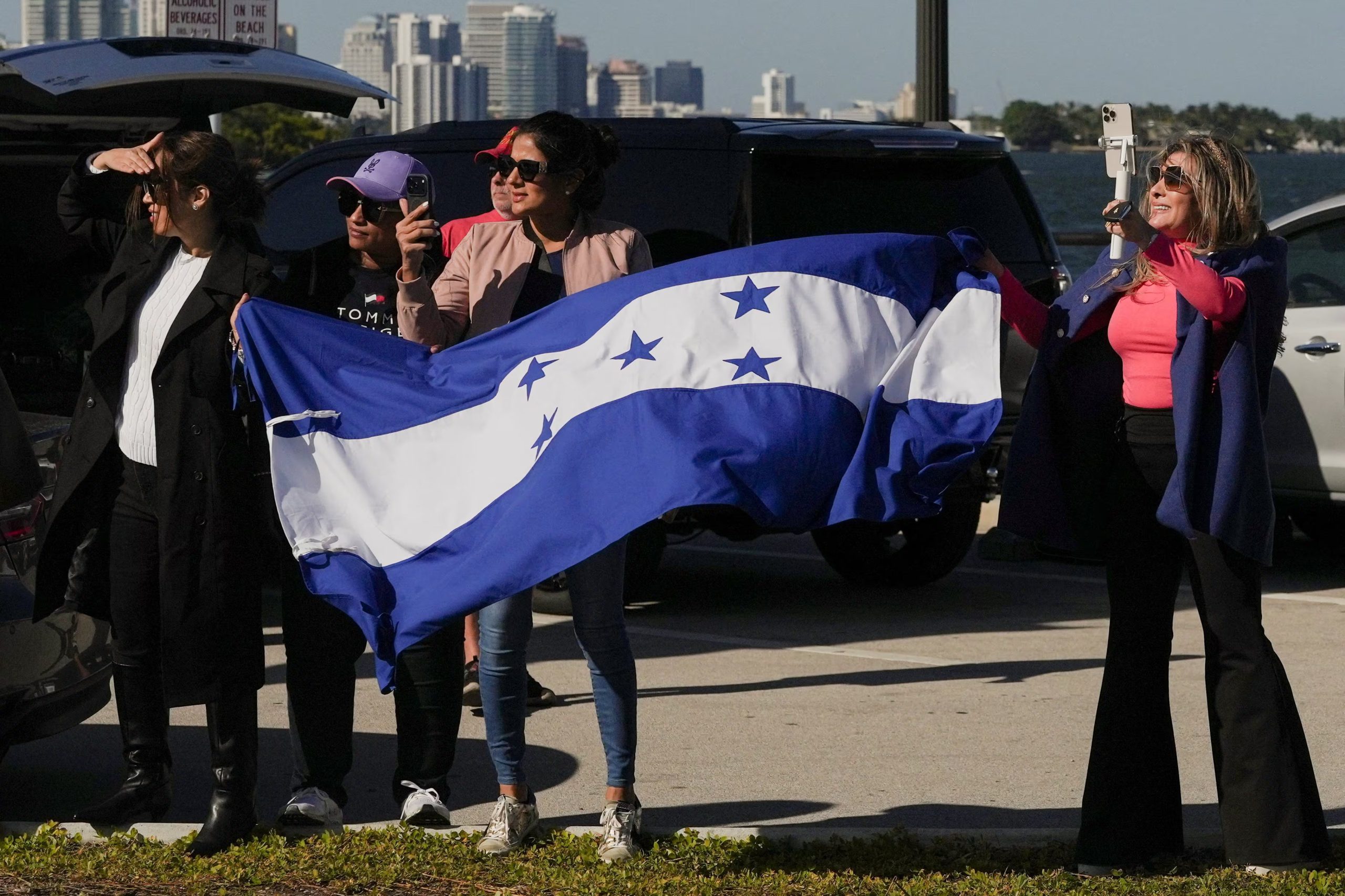 Supporters of U.S. President Donald Trump display a flag of Honduras as they stand along the roadside, as Trump's motorcade passes by on its way to Trump’s Mar-a-Lago club in Palm Beach, before he meets with Honduras' President Nasry Asfura, in West Palm Beach, Florida, U.S., February 7, 2026. REUTERS/Ken Cedeno