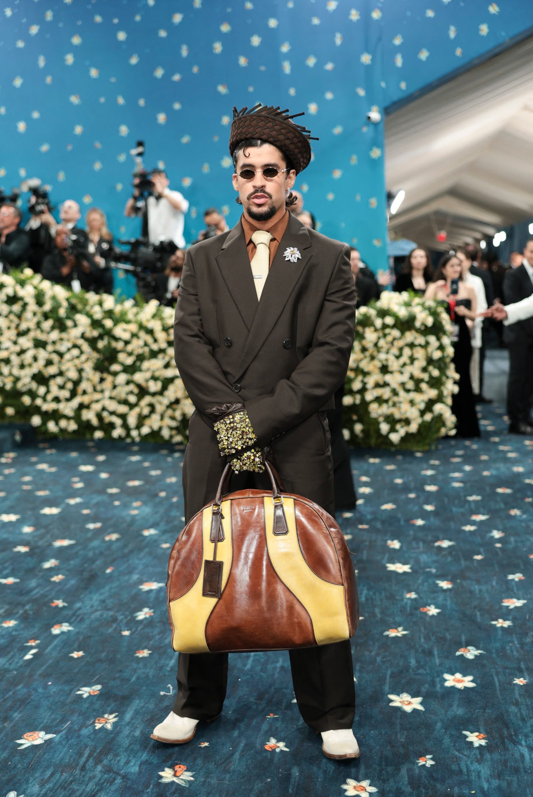 En la Met Gala 2025, el artista eligió camisa marrón, corbata dorada, broche de flor plateada, guantes oscuros y gafas redondas metálicas REUTERS/Mario Anzuoni