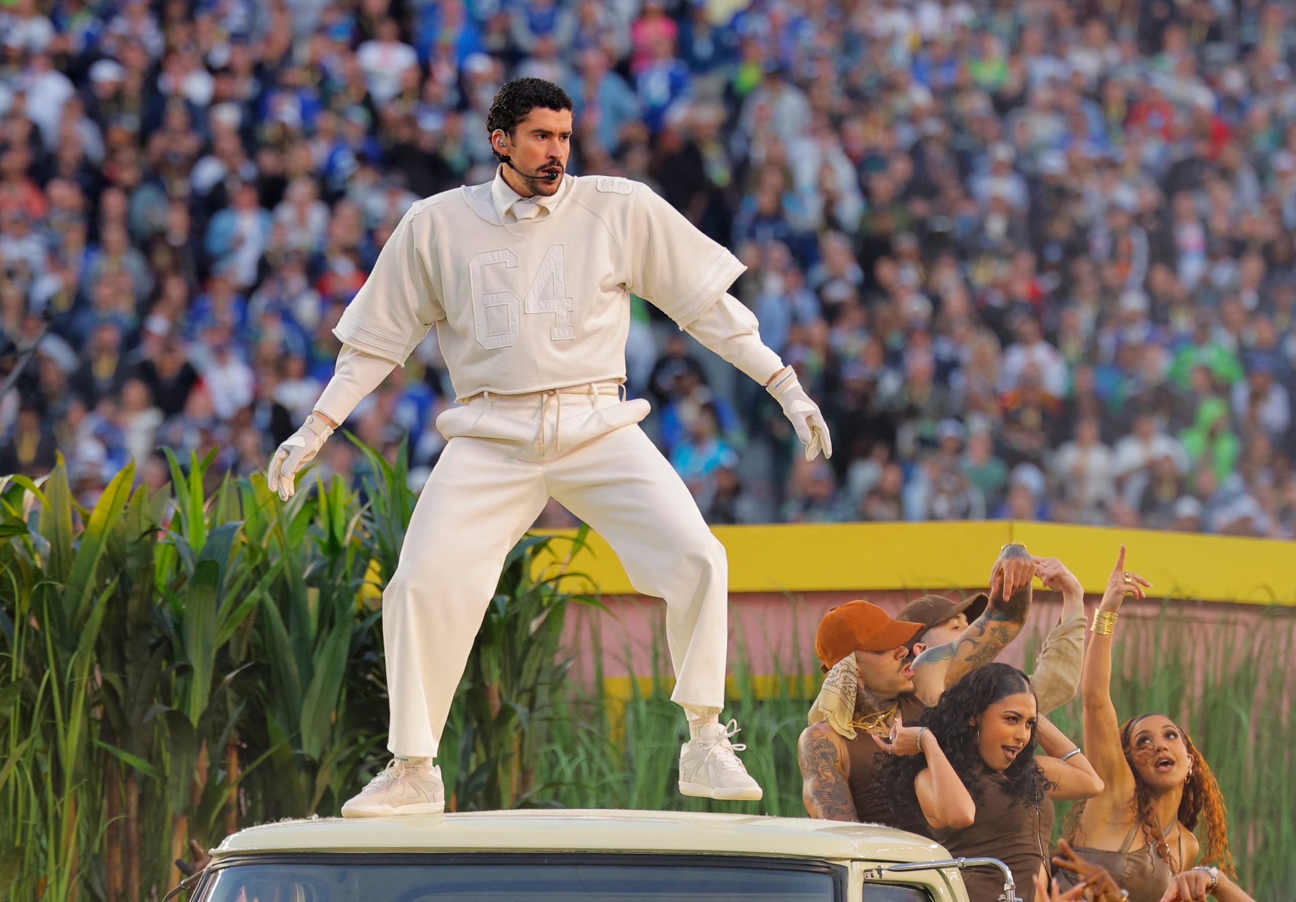 Bad Bunny eligió un outfit claro para el Super Bowl, combinando camiseta deportiva, pantalones anchos, guantes y zapatillas haciendo juego
REUTERS/Mike Blake