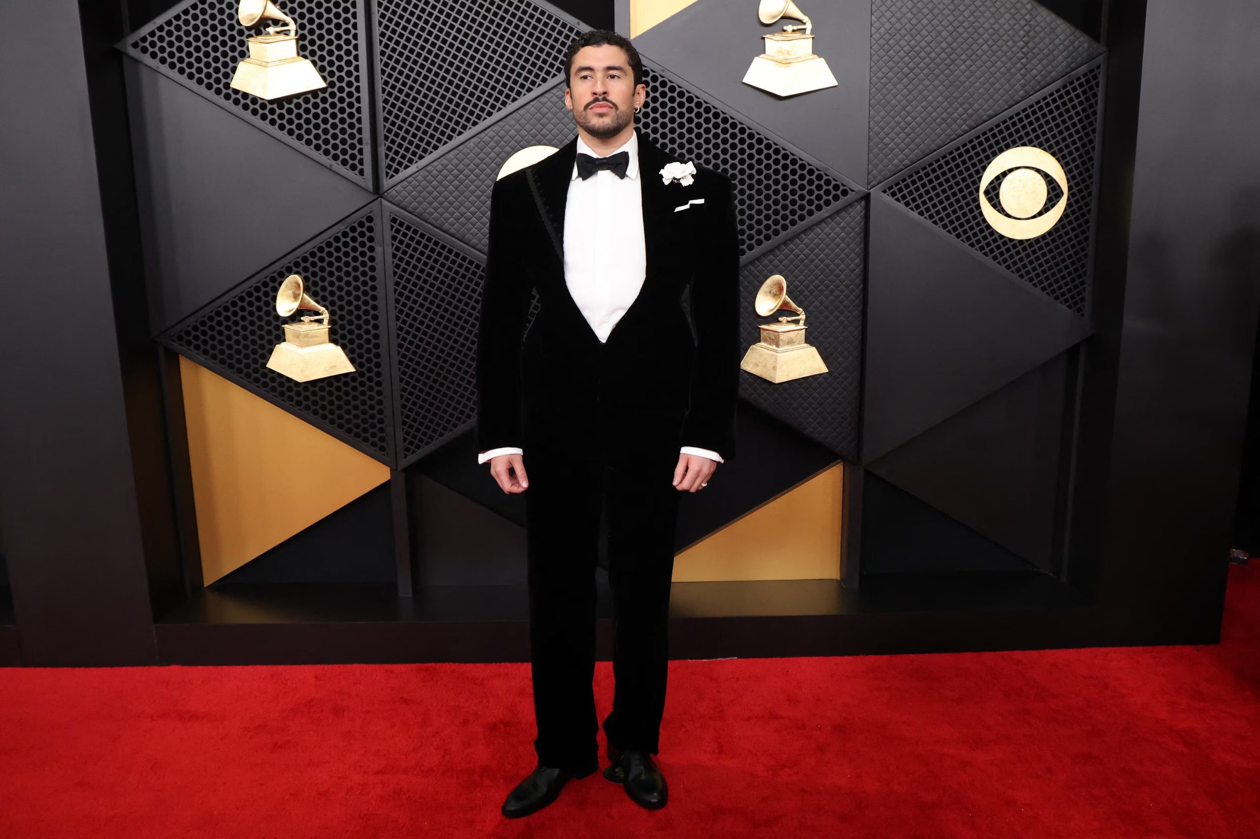 En los Grammy 2026, Bad Bunny optó por un esmoquin de terciopelo negro, camisa blanca, moño y un prendedor floral blanco en la solapa REUTERS/Mario Anzuoni