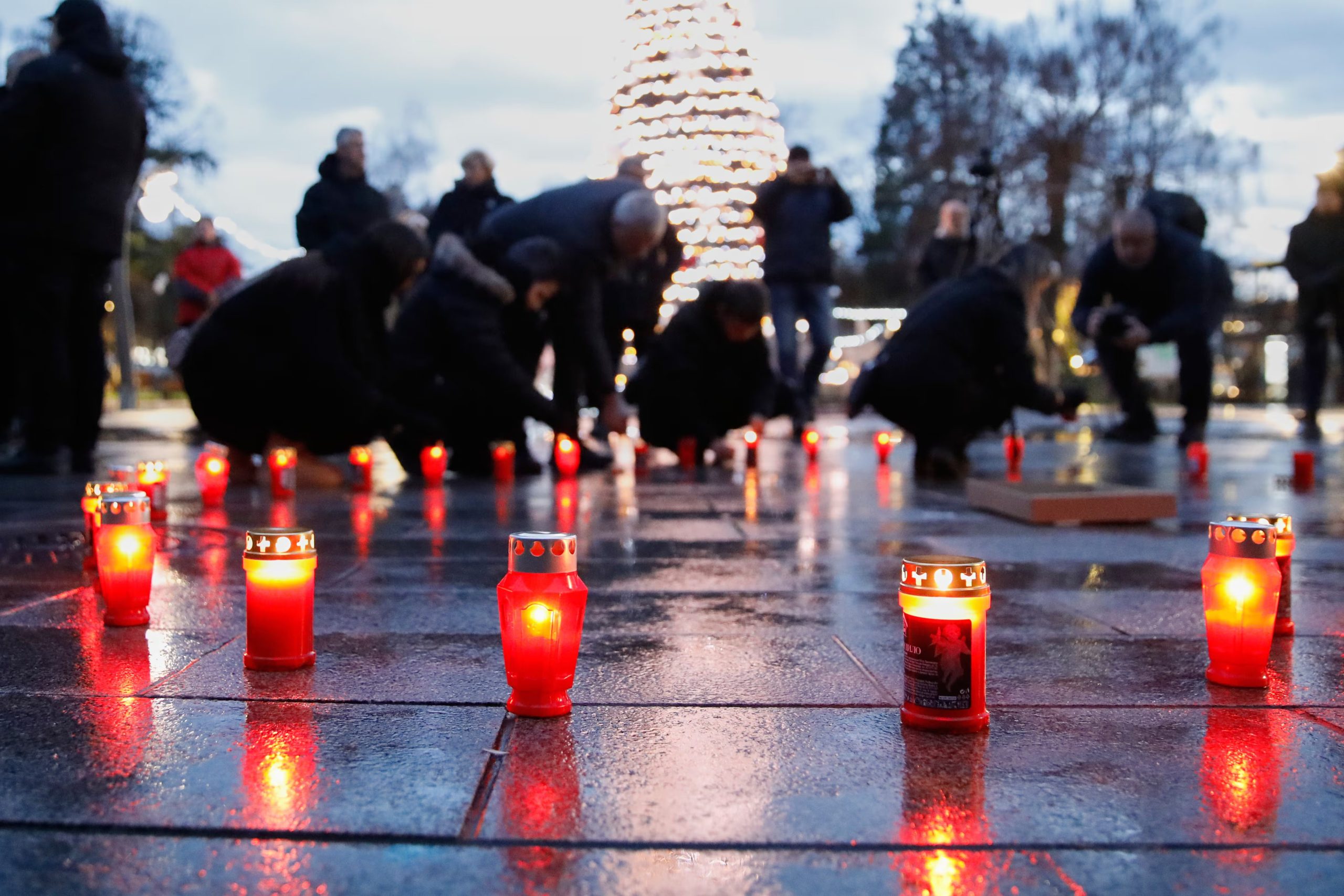 Personas encienden velas para expresar su compasión y solidaridad con las víctimas. (AP Photo/Boris Grdanoski)