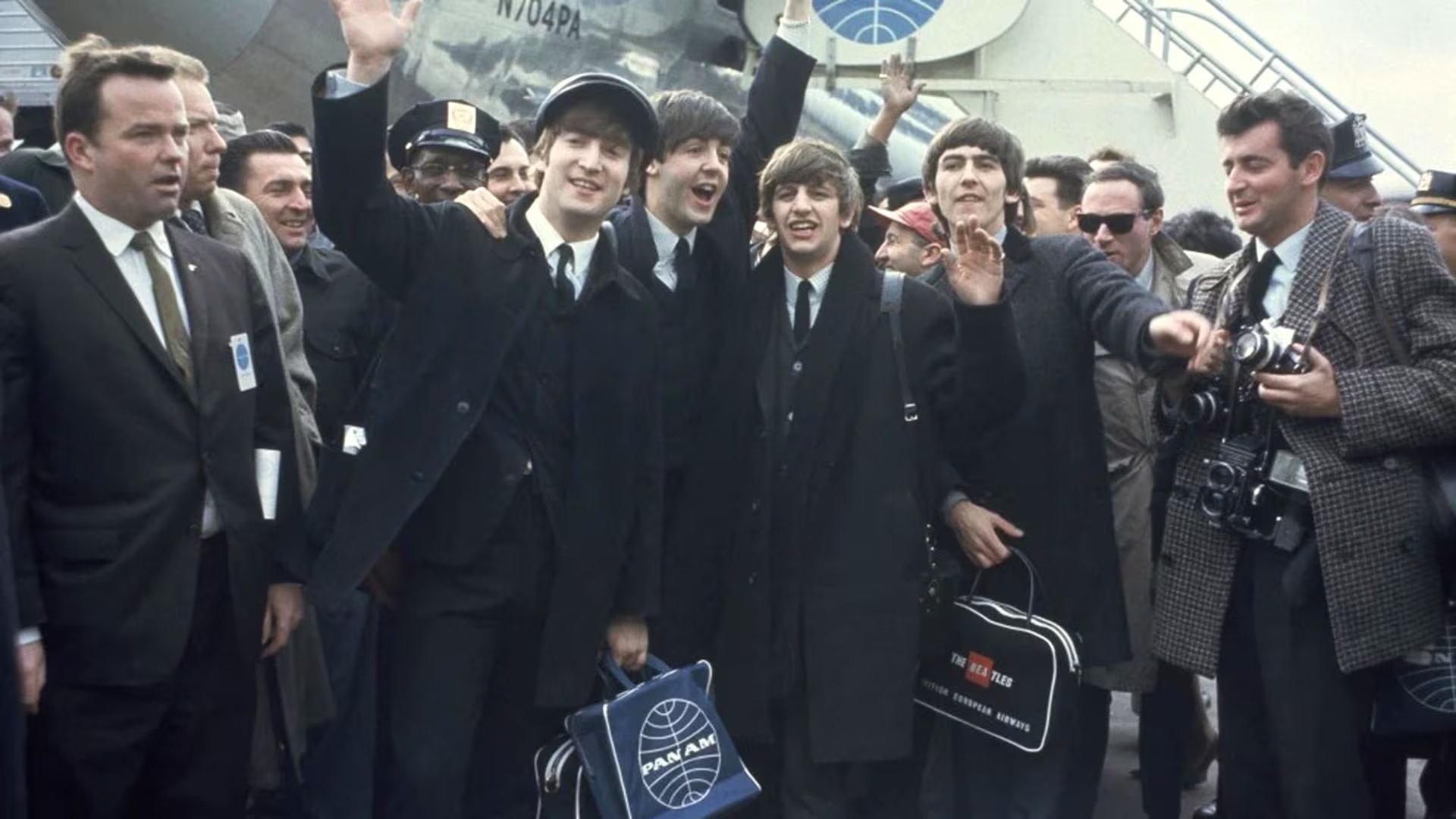 Los Beatles saludan a la multitud emocionada tras aterrizar en el aeropuerto JFK de Nueva York para su primera gira estadounidense. Habían volado en un avión de la línea aérea Panam (AP)