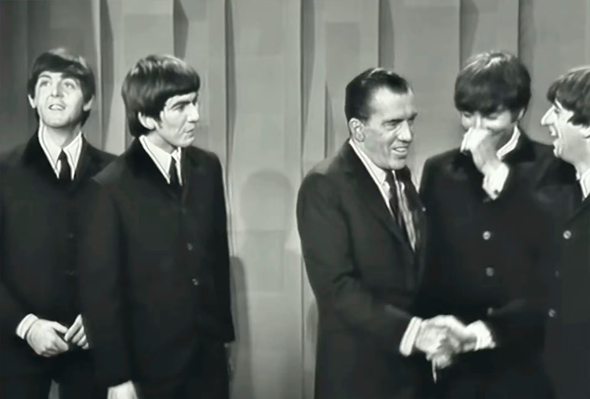 Los miembros de Los Beatles, Paul McCartney, George Harrison, John Lennon y Ringo Starr, comparten un momento inolvidable con el presentador Ed Sullivan durante su histórica aparición en el show televisivo (Captura de video)