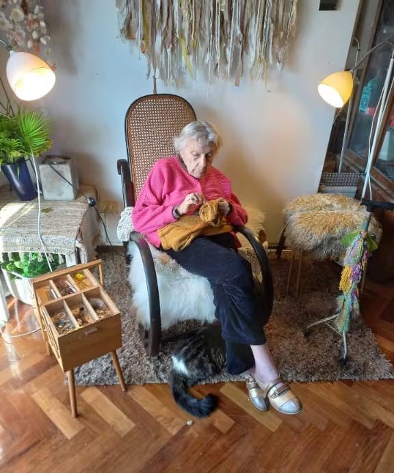 Su madre Nieves concentrada en las puntadas sobre su mecedora