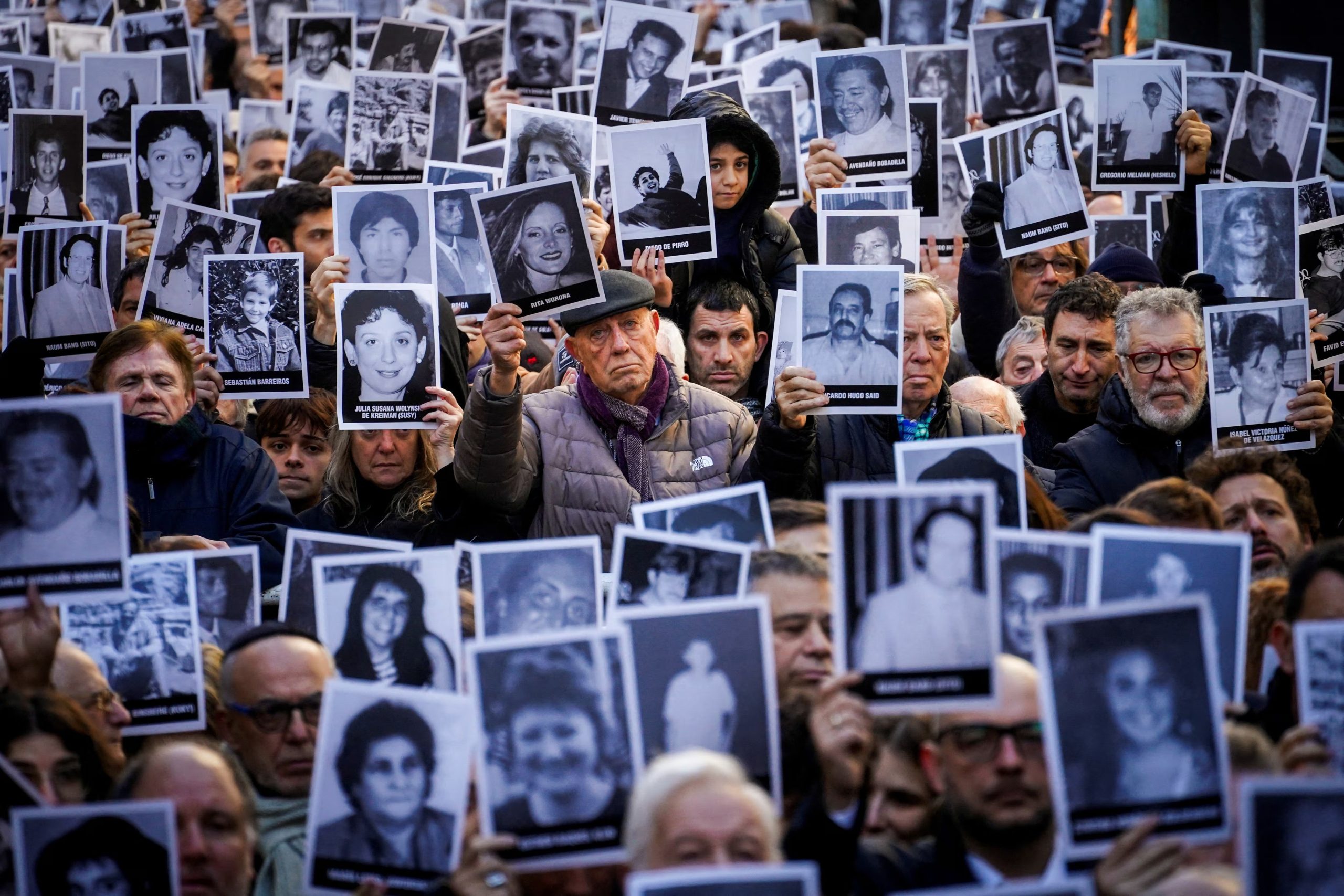 Manifestantes sostienen imágenes de las víctimas del atentado a la AMIA. REUTERS/Mariana Nedelcu
