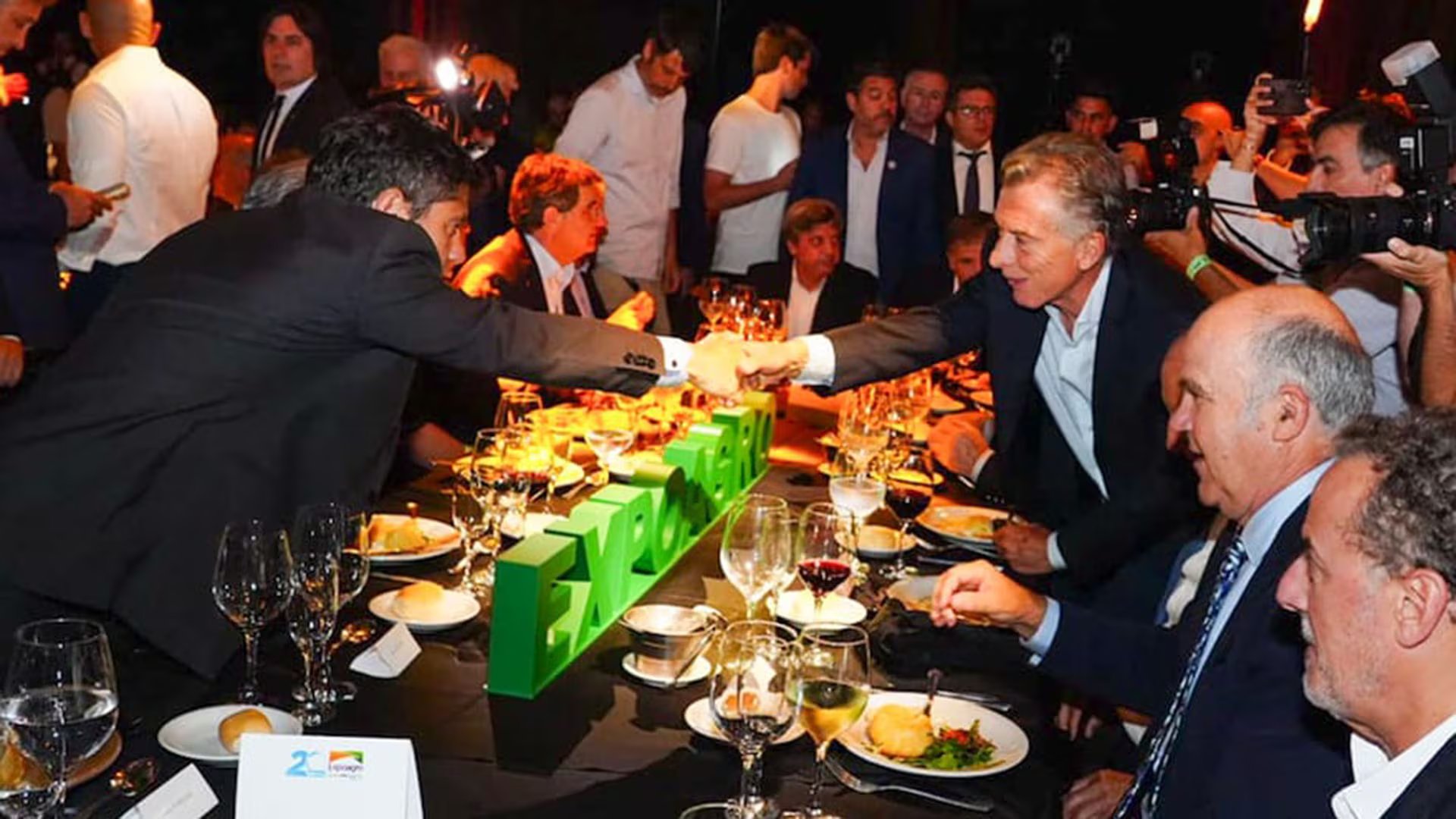El expresidente Mauricio Macri y el gobernador de Buenos Aires, Axel Kicillof, se saludan con un apretón de manos en la cena anual de Expoagro, ante la mirada de asistentes y fotógrafos. (Expoagro)