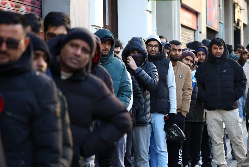 Cola frente al consulado de Pakistán en Barcelona para solicitar certificados de antecedentes penales, un documento necesario para el programa de regularización migratoria anunciado recientemente por el Gobierno español, en Barcelona, ​​España, el 30 de enero de 2026. (REUTERS/Albert Gea)