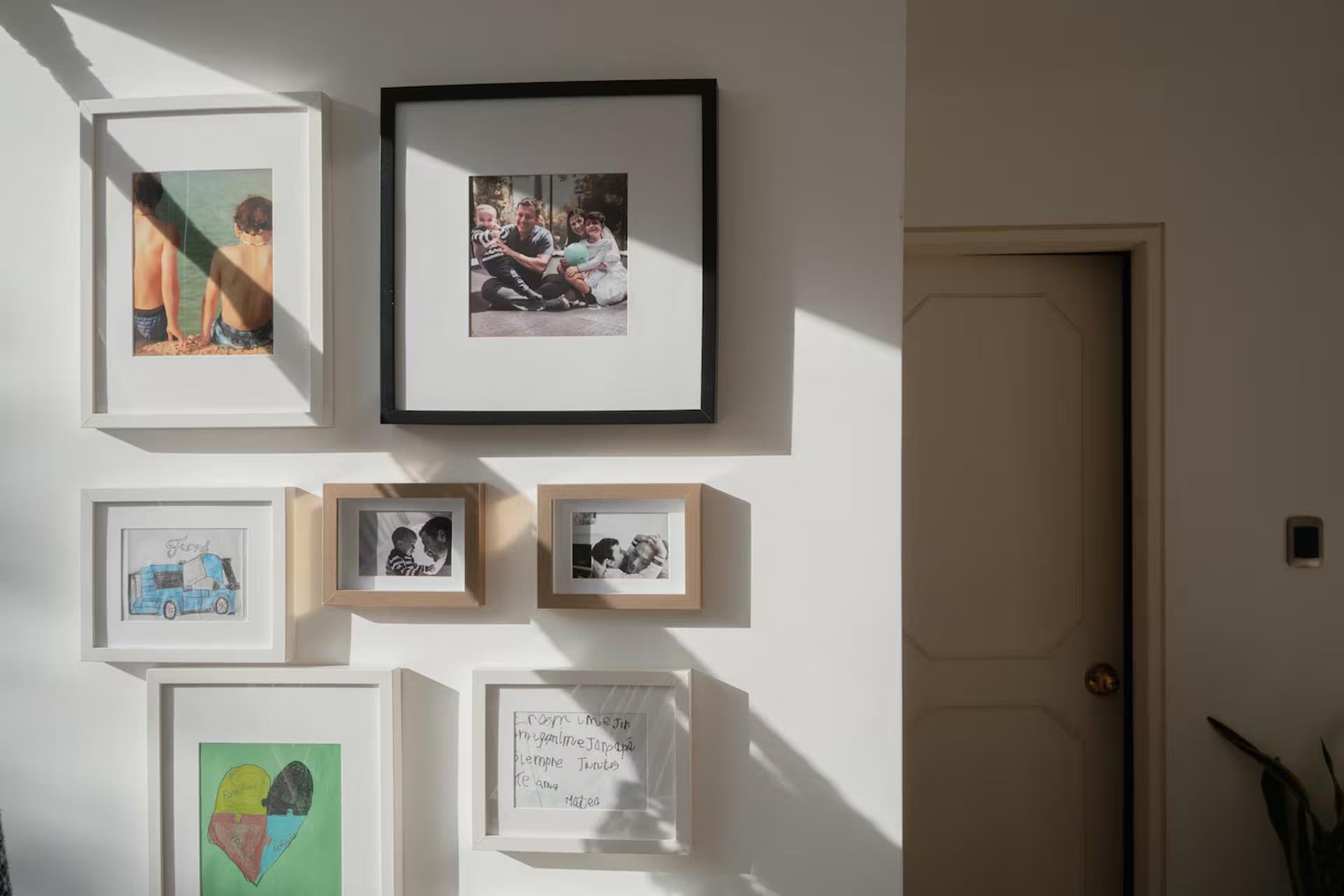 Cuadros cuelgan en una pared de la casa del preso político Luis Tarbay en Caracas, Venezuela. La fotografía enmarcada en la parte superior derecha muestra a su esposa, Vanessa, y a sus hijos (Andrea Hernández Briceño/Para The Washington Post)