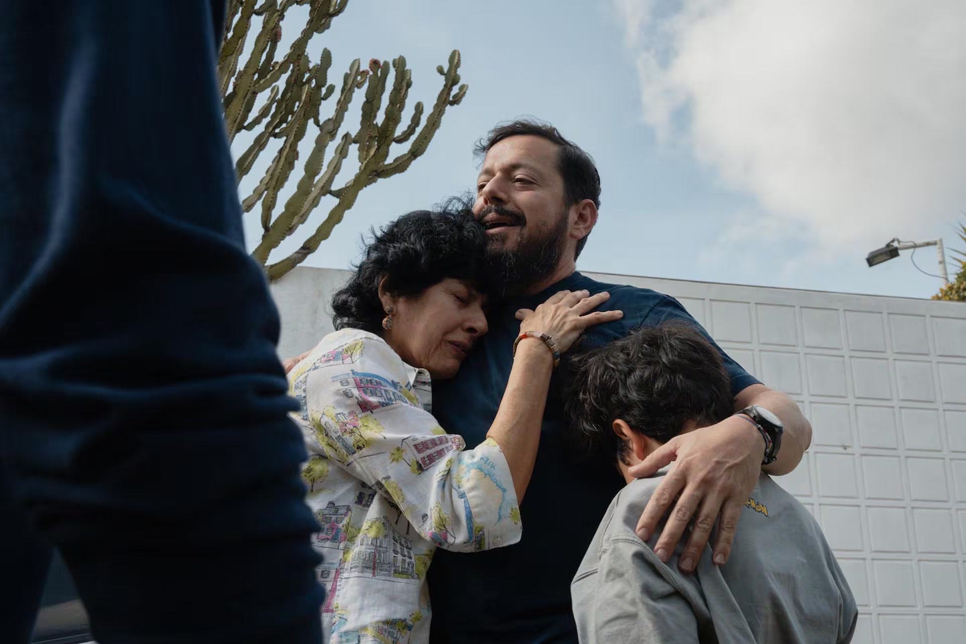 Luis abraza a su madre, Gina de Tarbay, y a su hijo Mateo, de 8 años, afuera de su residencia en Caracas el 8 de febrero (Andrea Hernández Briceño/Para The Washington Post)


