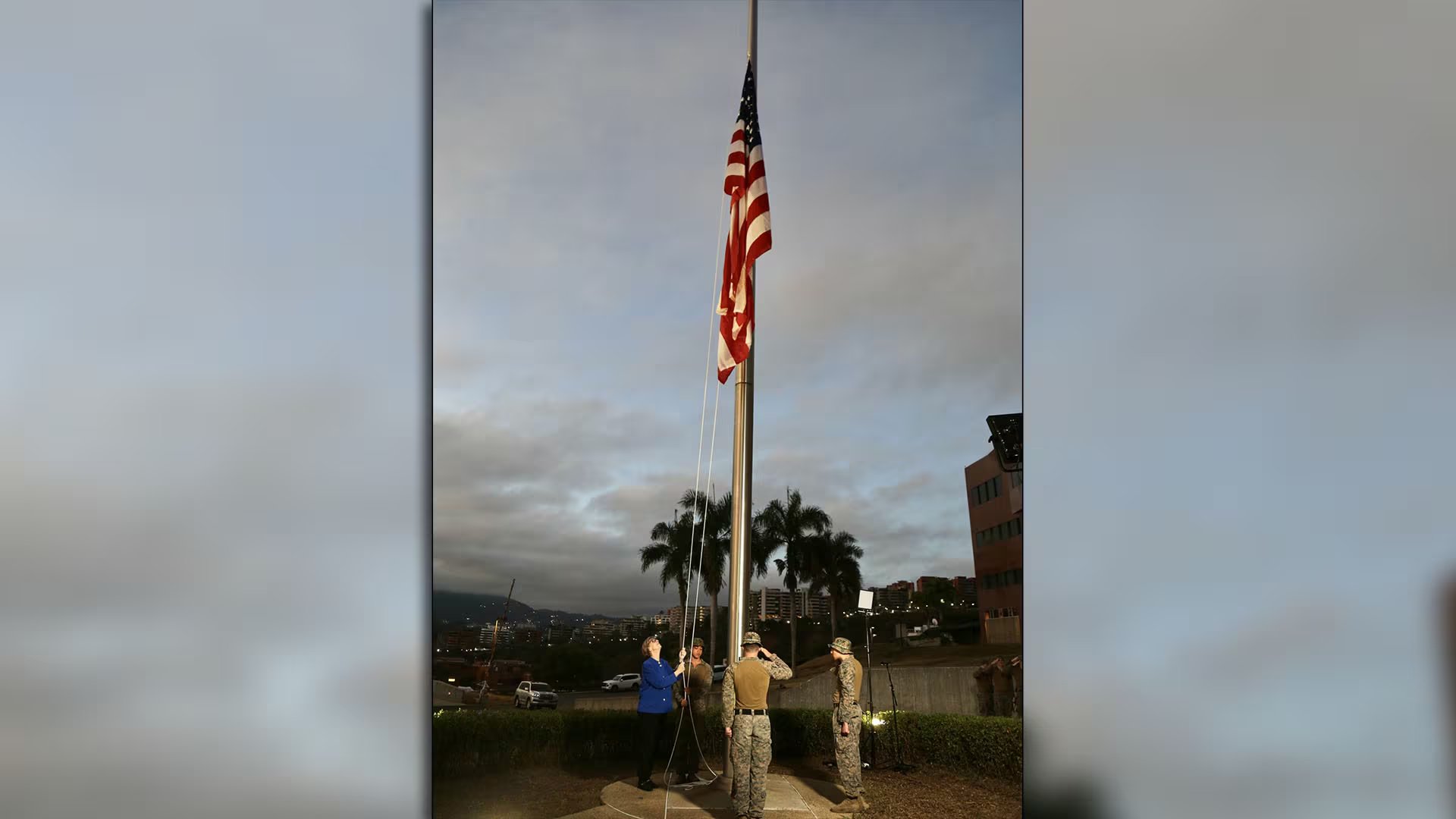 Personal de la Embajada de Estados Unidos en Venezuela participa en una ceremonia con la bandera nacional a media asta, simbolizando respeto o luto. (@usembassyve)