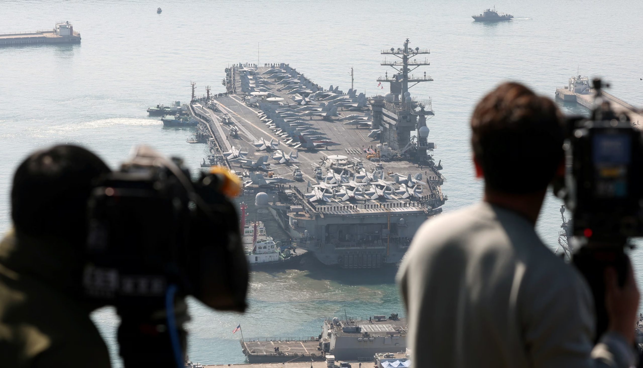 Miembros de la prensa filman al portaaviones estadounidense USS Nimitz acercándose a una base naval en Busan, Corea del Sur (REUTERS/Archivo)