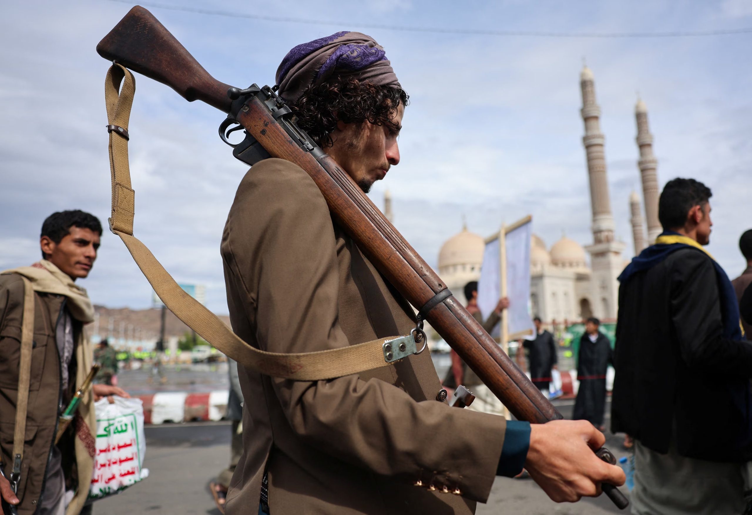 Un hombre que porta un arma observa una manifestación de partidarios hutíes en solidaridad con Irán, el 27 de marzo (REUTERS/Khaled Abdullah)