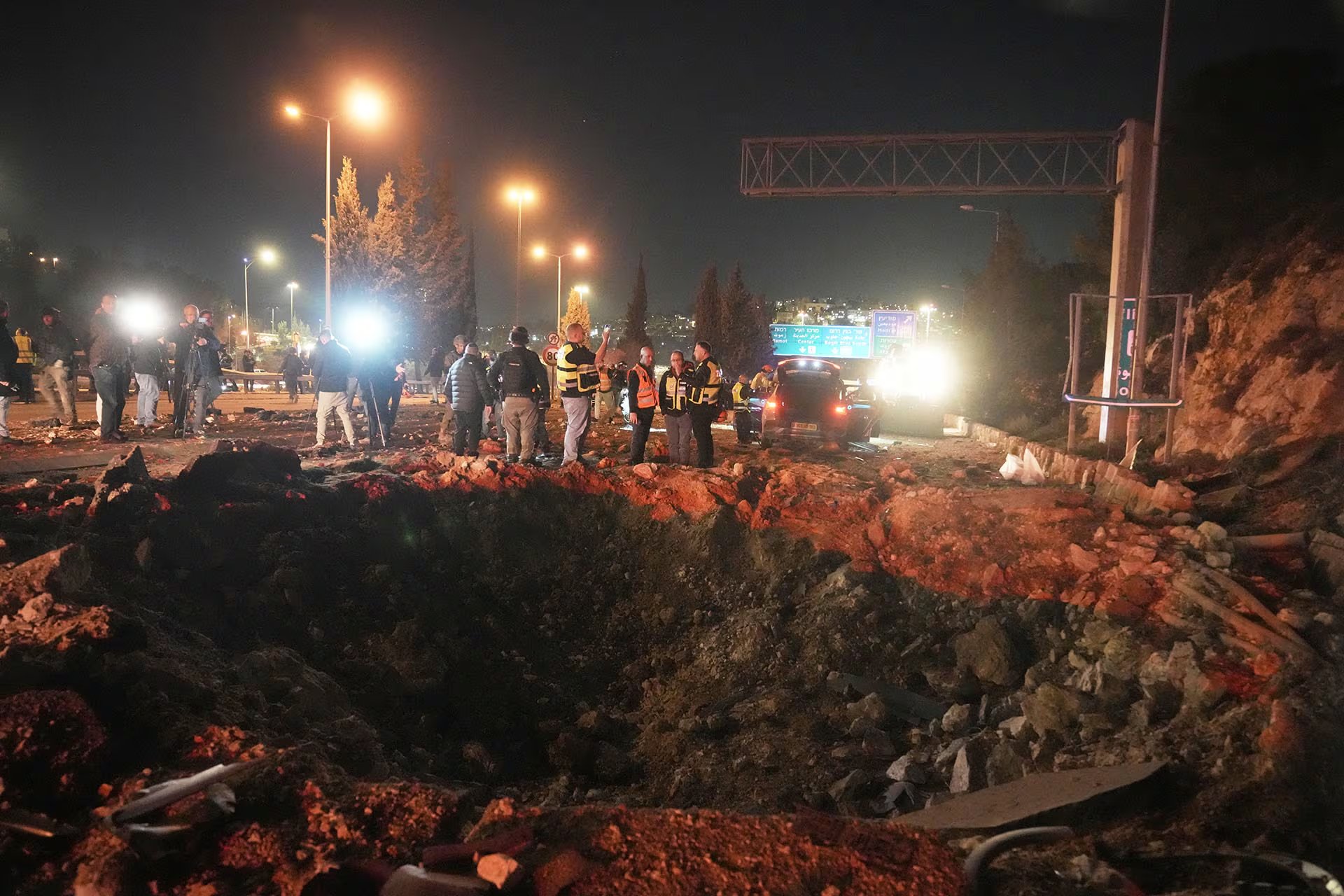 Fuerzas de seguridad israelíes inspeccionan los daños causados en una carretera por un misil lanzado desde Irán, en Jerusalén.(AP Foto/Mahmoud Illean)