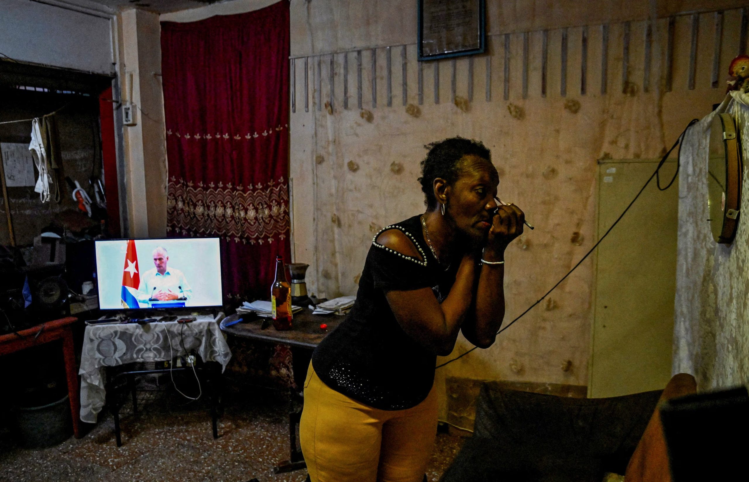 Una mujer cubana se maquilla mientras escucha el anuncio de Díaz-Canel (REUTERS/Norlys Perez)