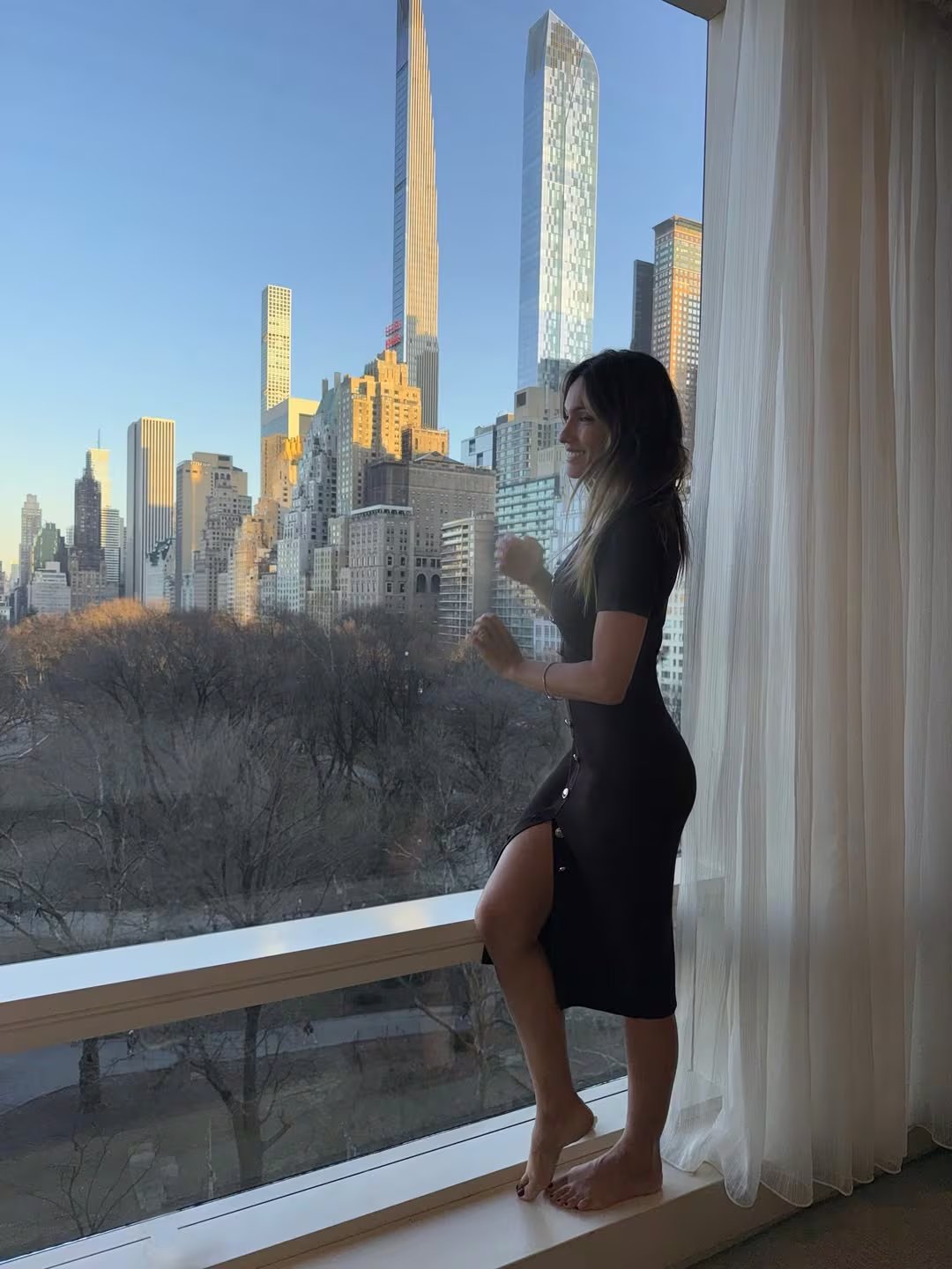 Descalza, a cara lavada y con un vestido color marrón Pampita posó en la ventana del hotel