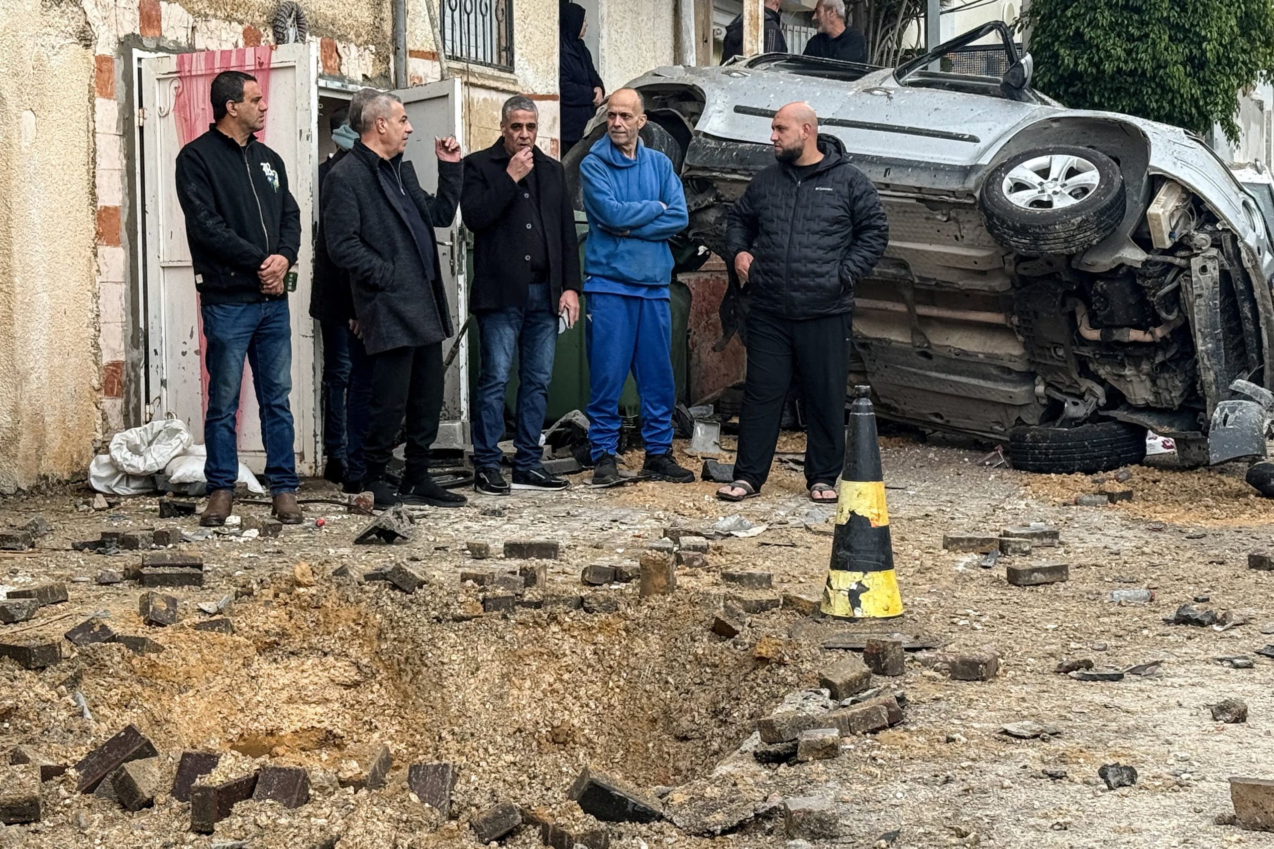 Unidades de emergencia y policía retiraron escombros en Kafr Qassem y asistieron a residentes, incluida una anciana escoltada hacia una ambulancia. (REUTERS/Rami Amichay)