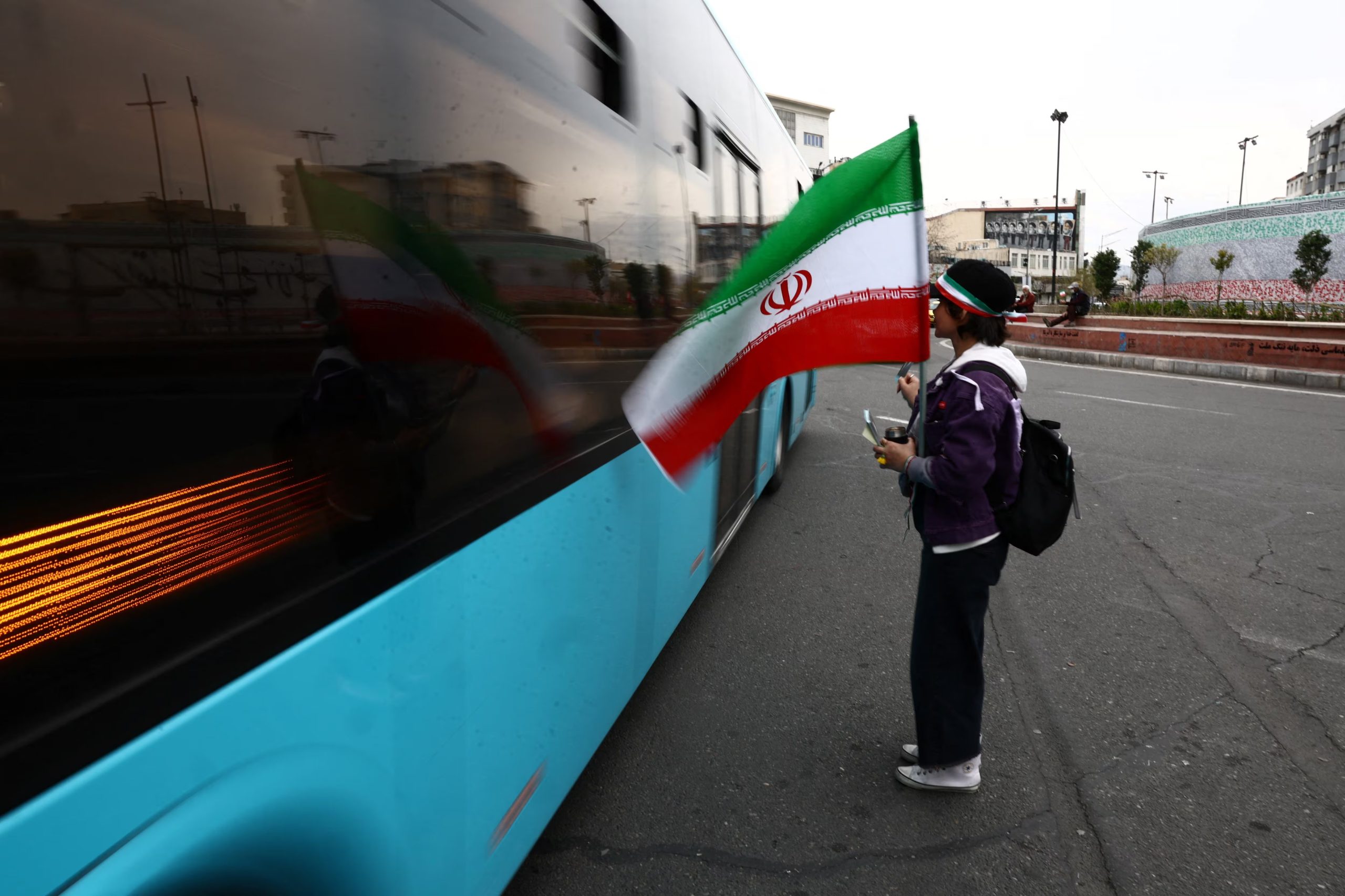 Una mujer sostiene una bandera iraní en Teherán en medio del conflicto con Estados Unidos e Israel. La campaña 