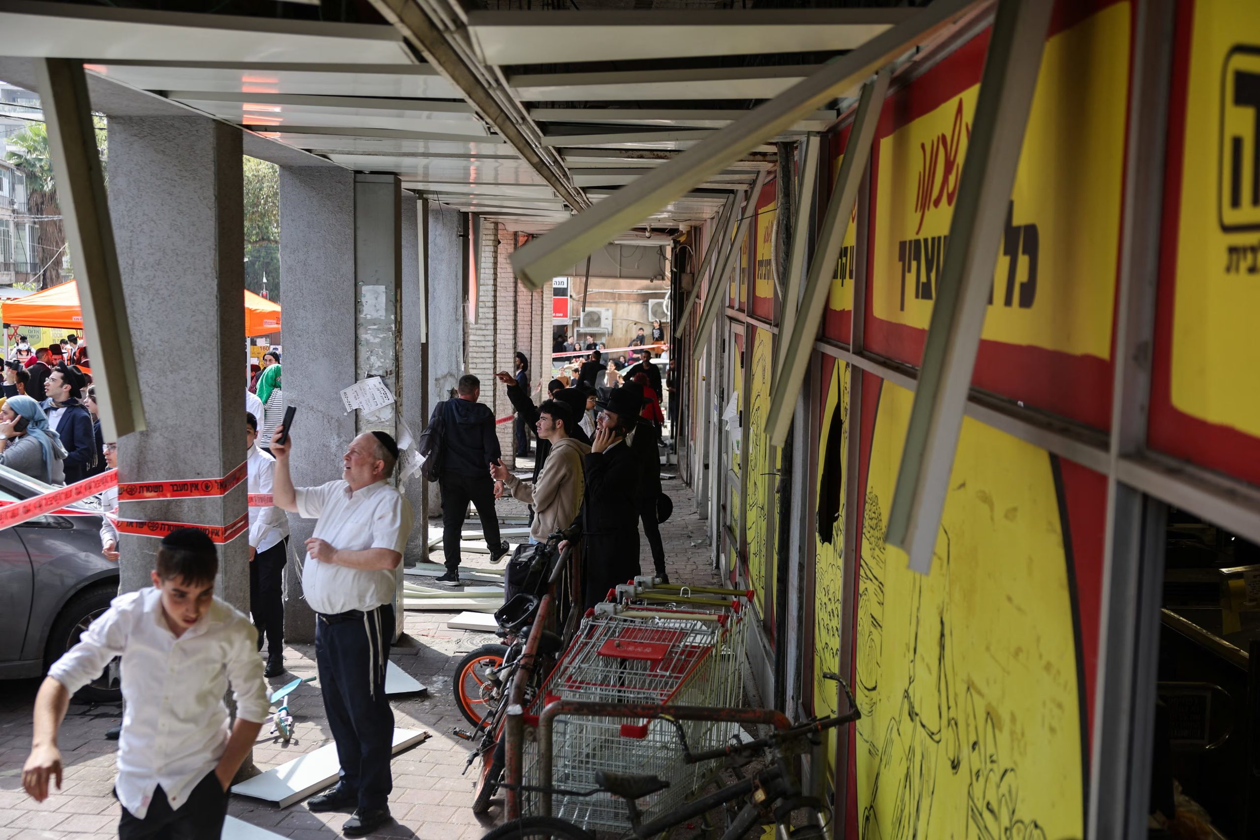 Un grupo de vecinos observa los daños que dejó un nuevo ataque de Irán contra el centro de Israel (REUTERS/Tyrone Siu)