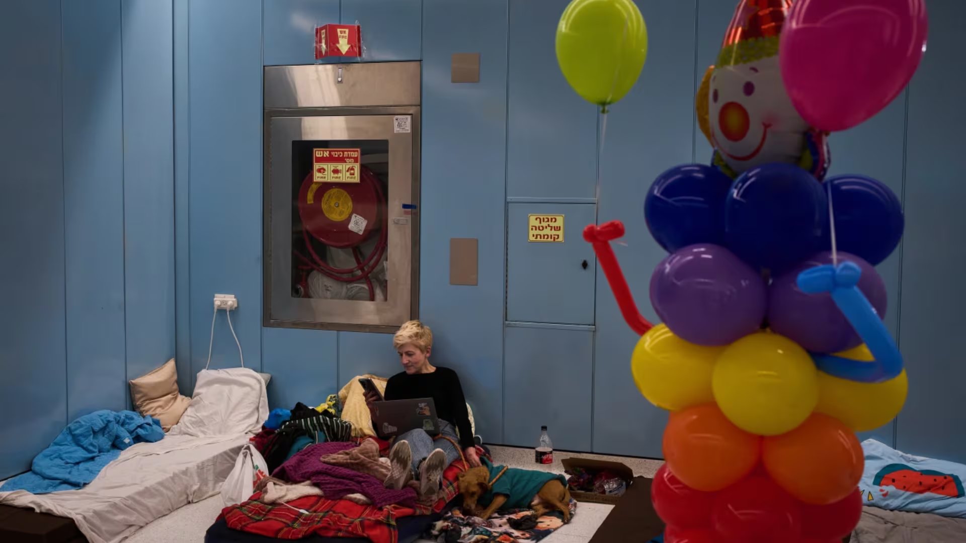 Una mujer se sienta sobre un colchón en una estación de metro subterránea que sirve como refugio antibombas ante la amenaza de posibles ataques con misiles iraníes durante la festividad judía de Purim en Ramat Gan, Israel, el lunes 2 de marzo de 2026 (AP/Oded Balilty)