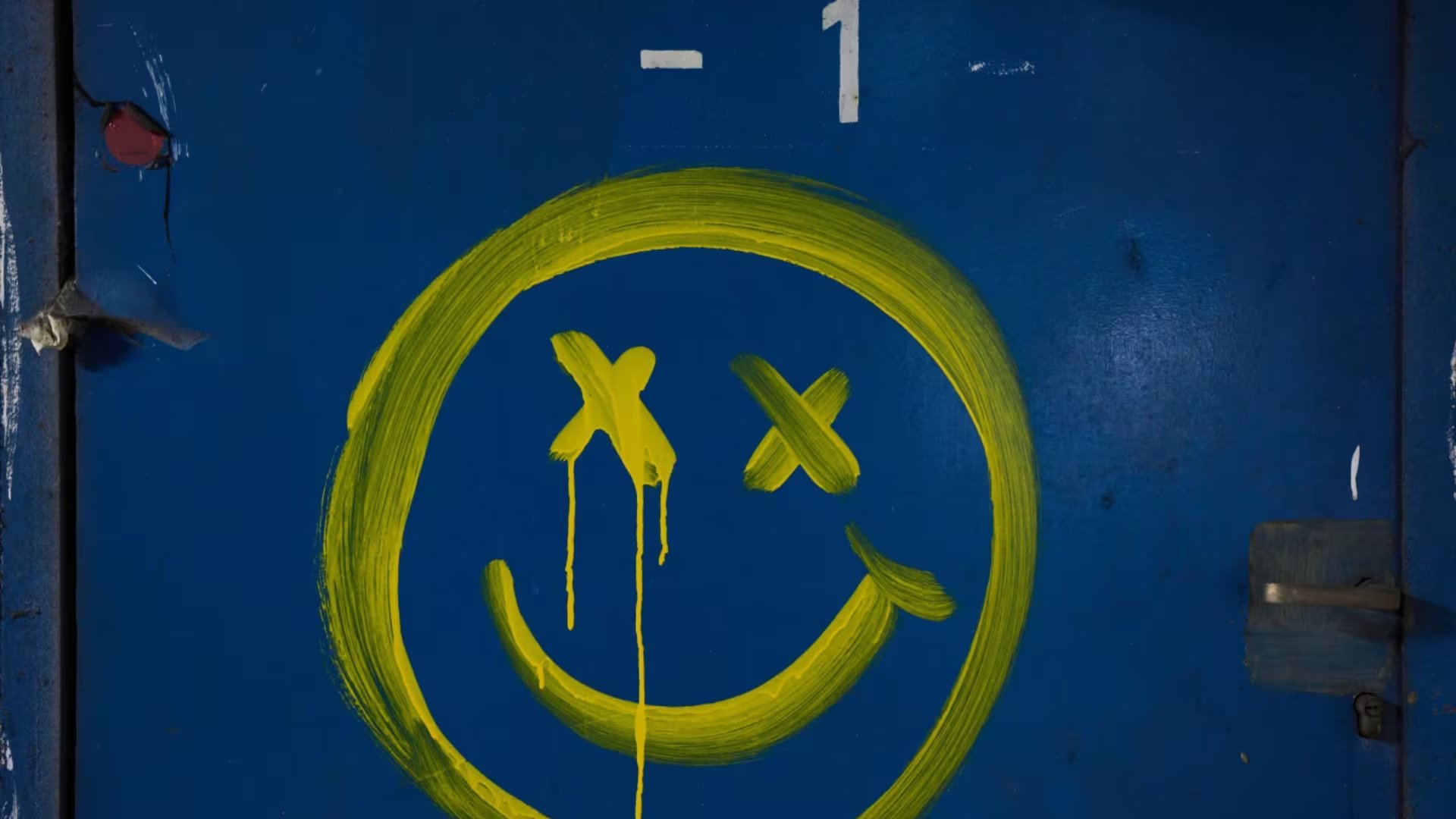 Una carita sonriente está pintada en una pared azul debajo de la estación central de autobuses de Tel Aviv, utilizada como refugio contra posibles ataques con misiles iraníes, el jueves 12 de marzo de 2026 (AP/Oded Balilty)