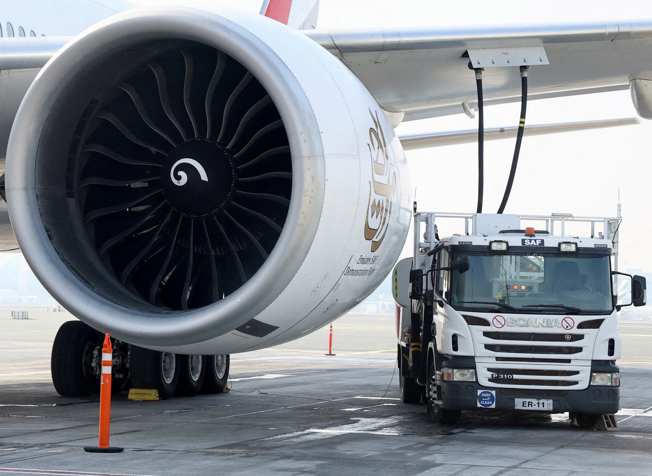FILE PHOTO: A fuel truck fills up the Emirates Airlines Boeing 777-300ER with Sustainable Aviation Fuel (SAF), during a milestone demonstration flight while running one of its engines on 100% (SAF) at Dubai airport, in Dubai, United Arab Emirates, January 30, 2023. REUTERS/Rula Rouhana/File Photo